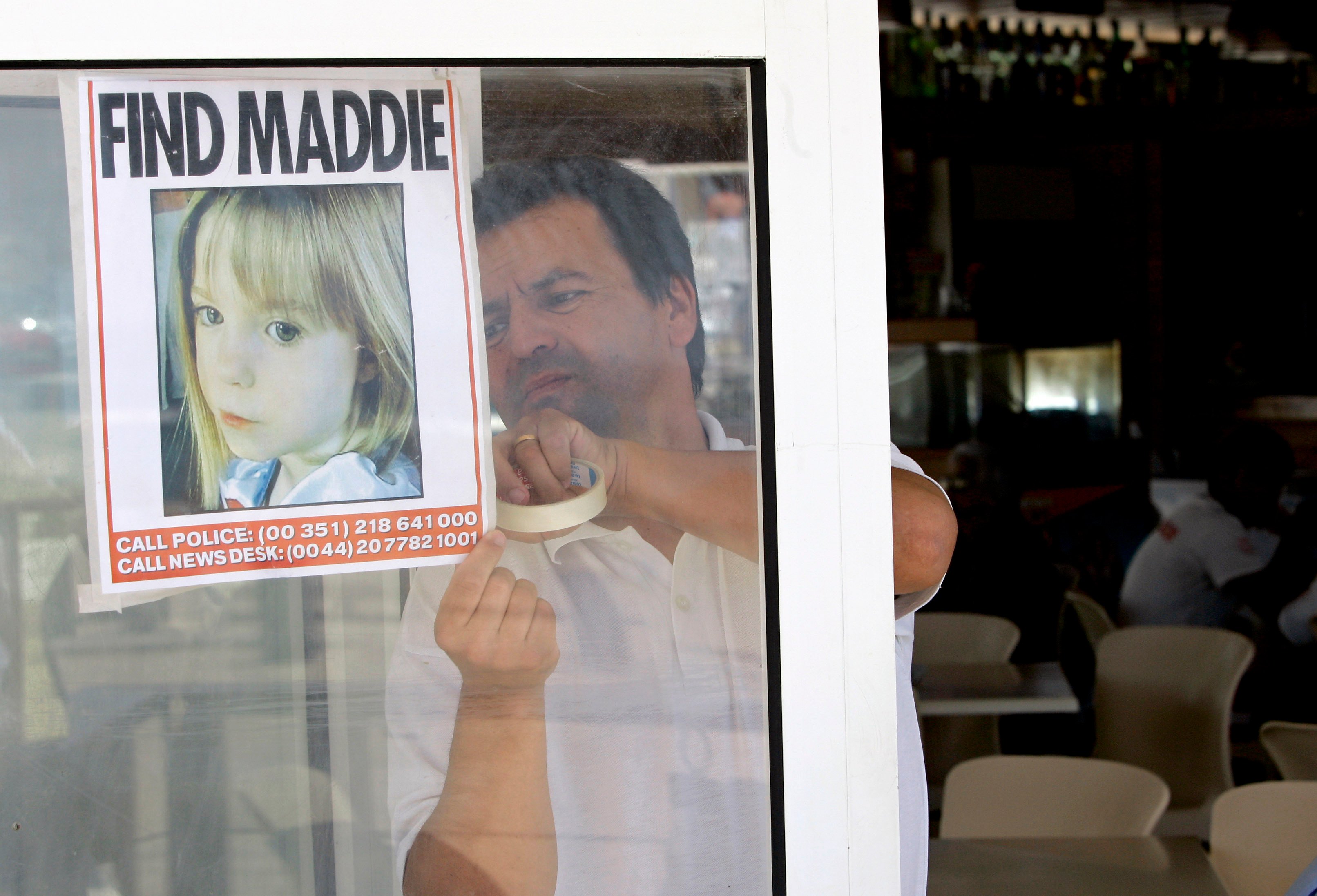 A waiter displays a picture of missing three-year-old girl Madeleine McCann on a restaurant window in Praia da Luz, Portugal, in May 2007. Photo: AP