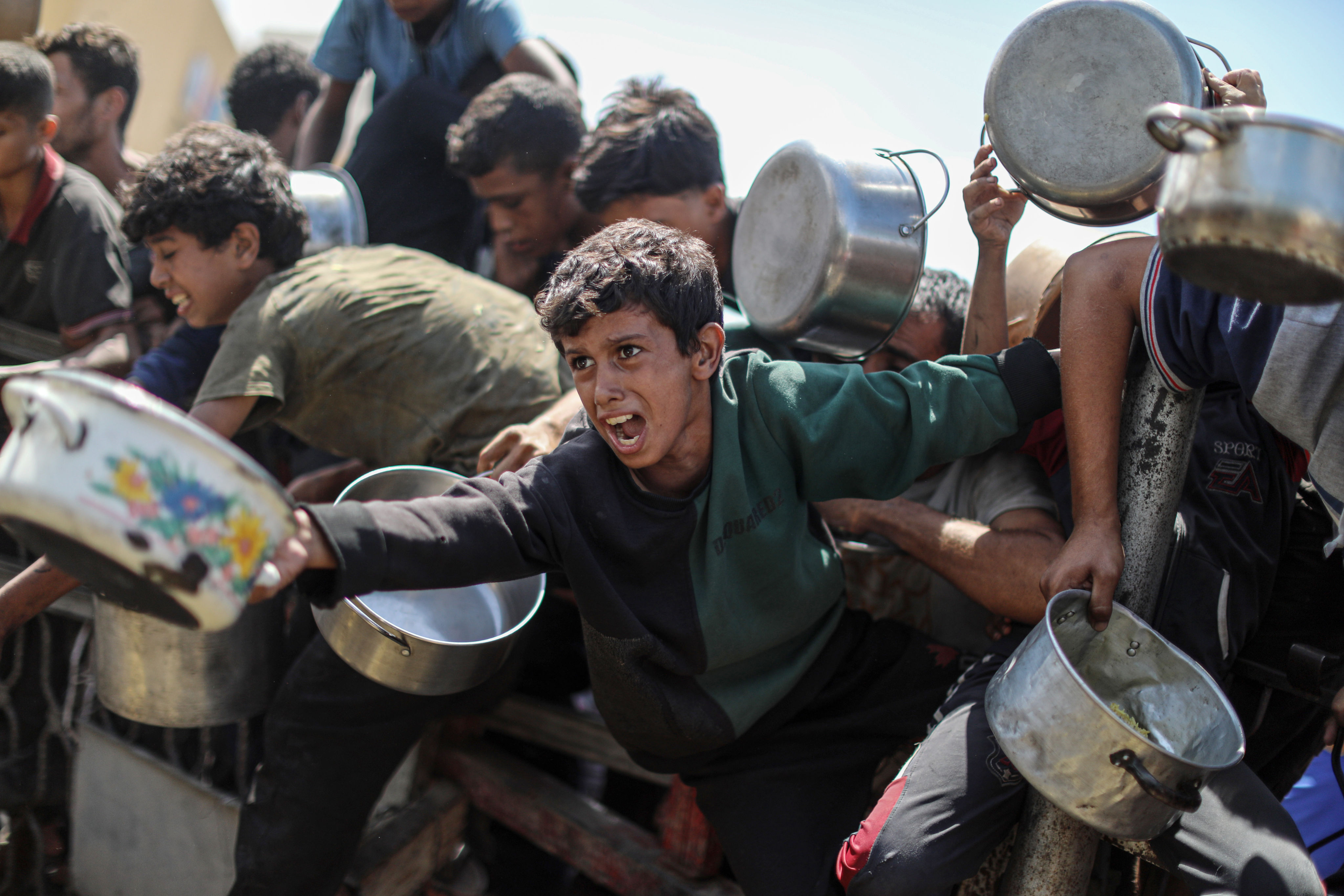 Palestinian children wait to receive food from a charity kitchen in Gaza City on Wednesday. Photo: APA Images/Zuma Press Wire/dpa