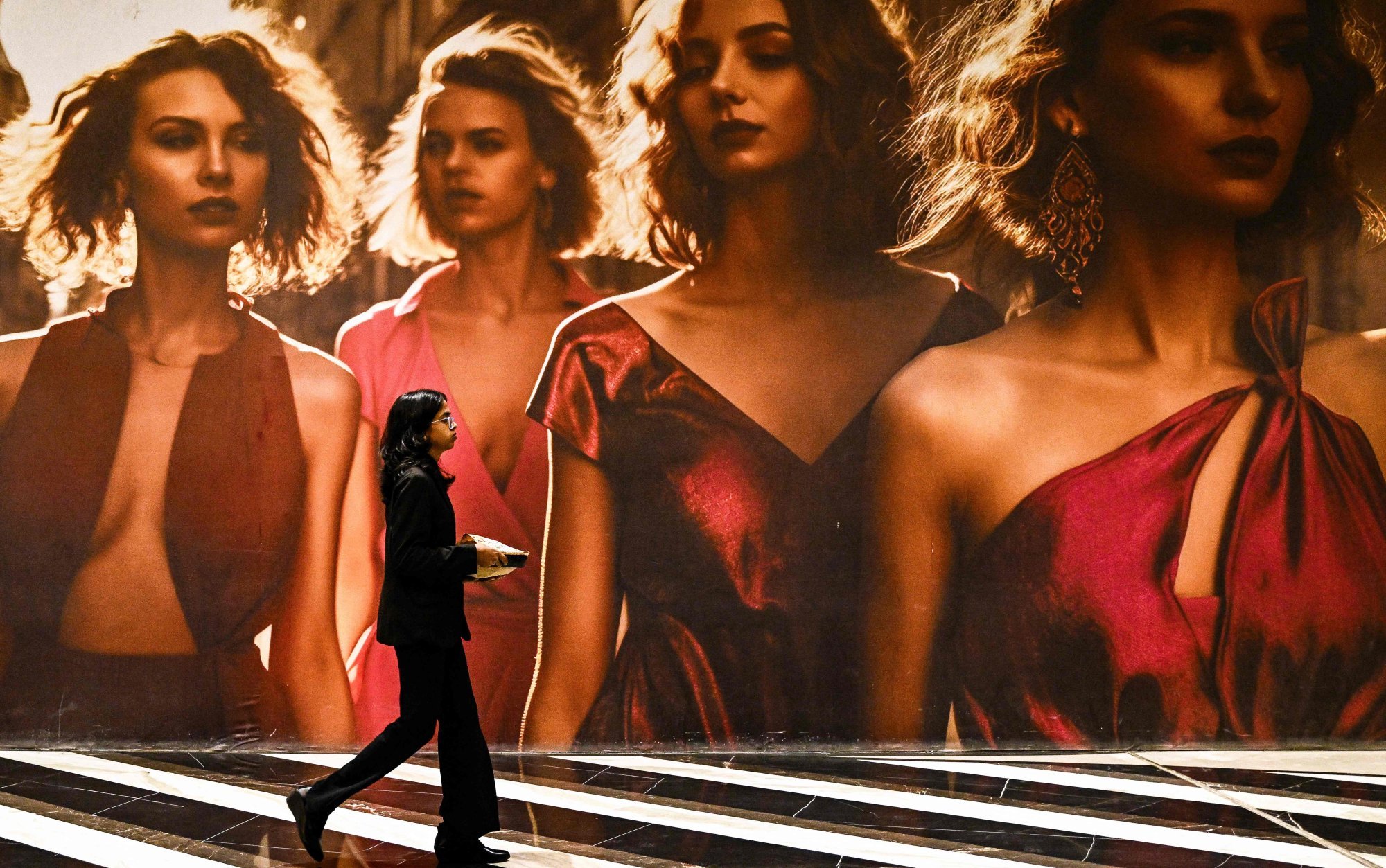 A young woman walks past an apparel advertisement at a shopping centre in Bengaluru on Tuesday. Photo: AFP