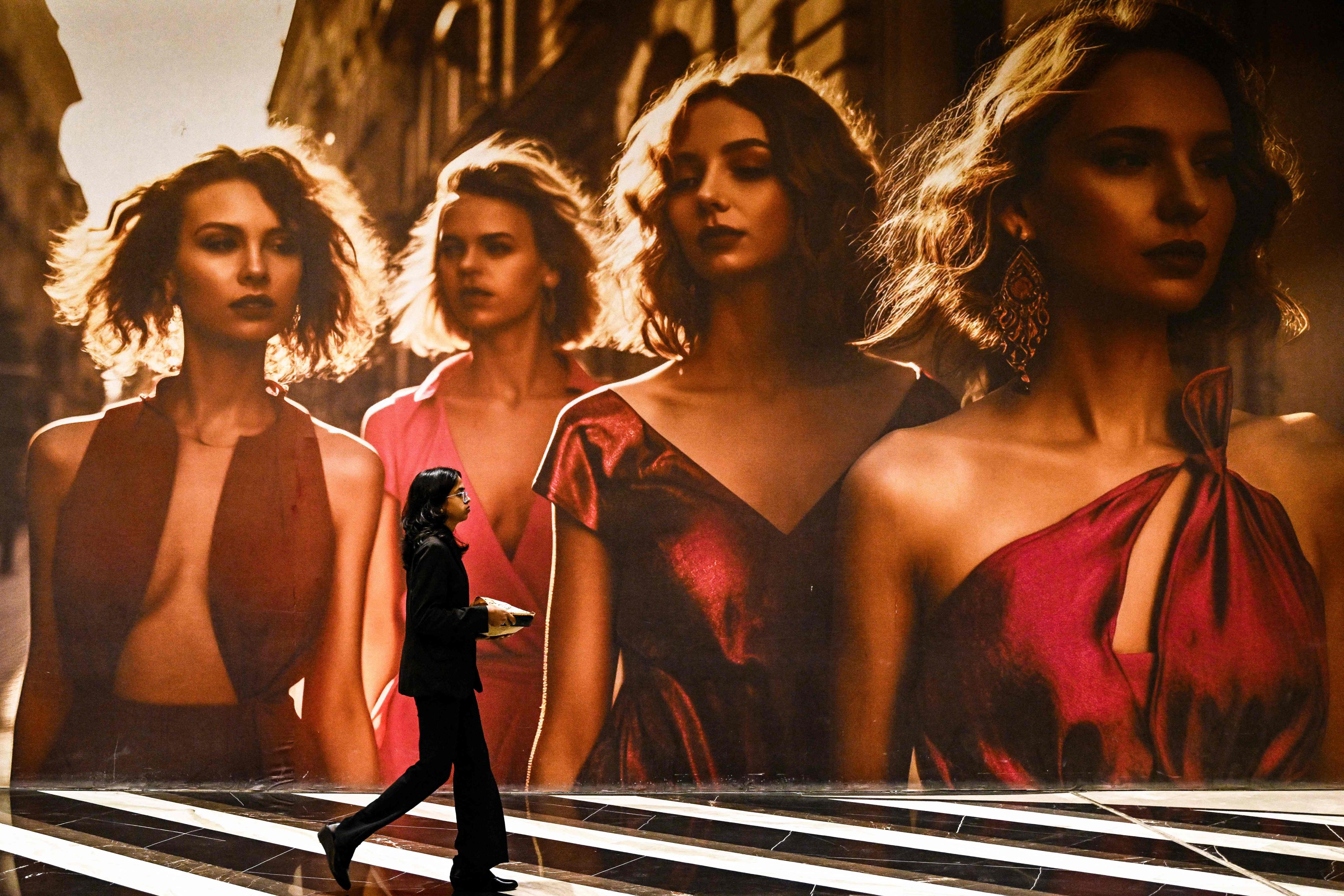 A young woman walks past an apparel advertisement at a shopping centre in Bengaluru on Tuesday. Photo: AFP