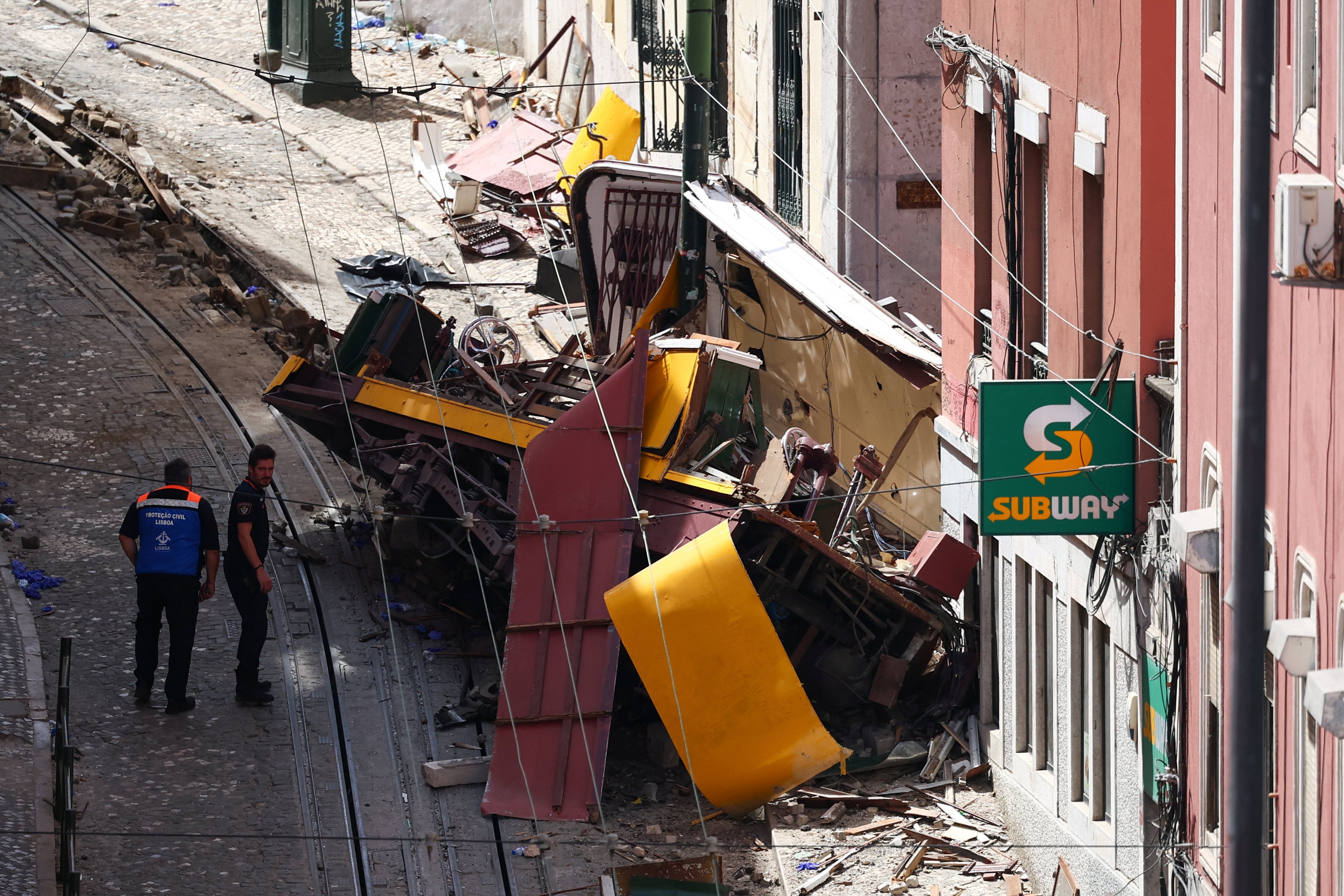 Police officers inspect the site where a tourist streetcar derailed and crashed in Lisbon, Portugal on Thursday. Photo: Reuters