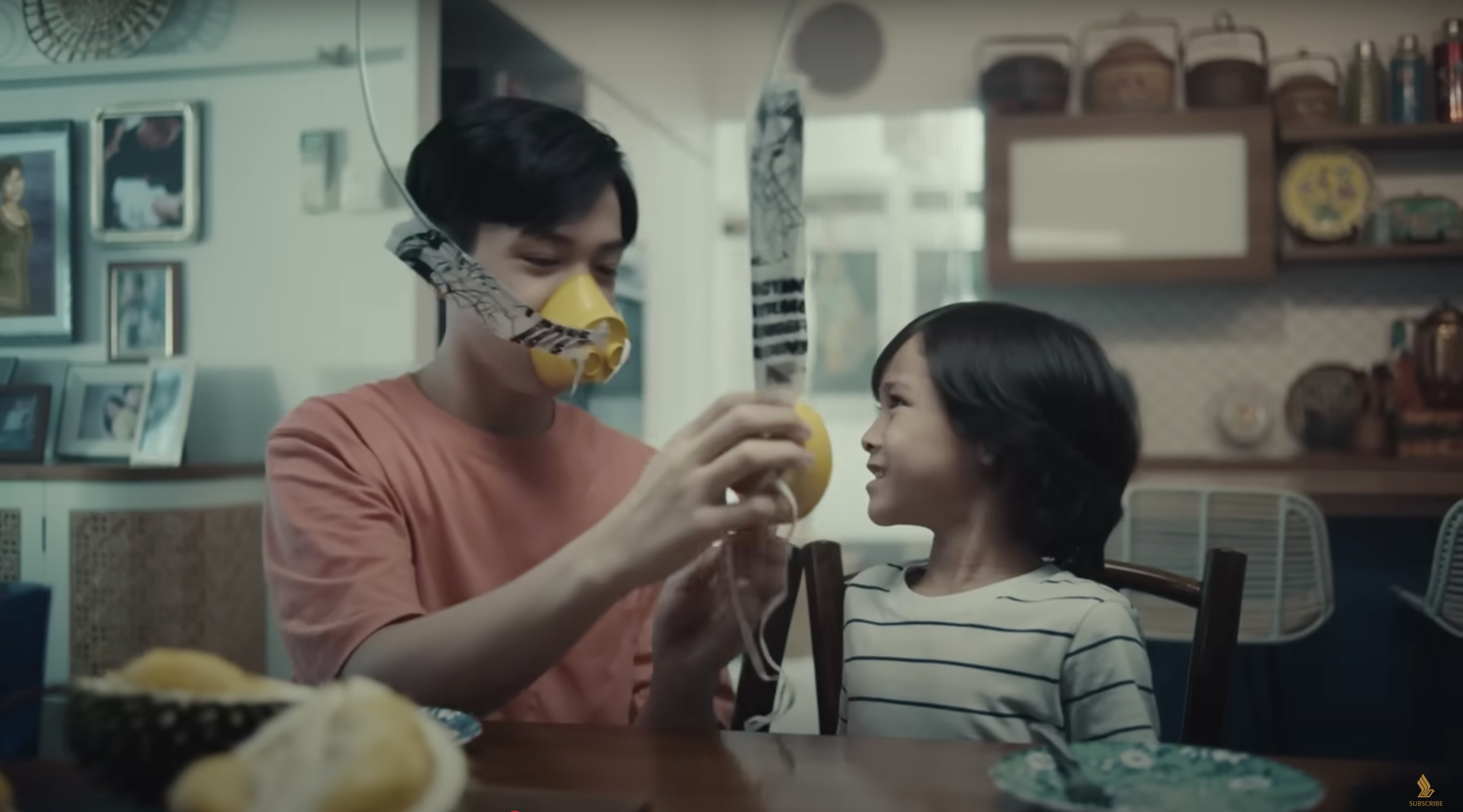 A still from Singapore Airlines’ new in-flight safety video shows a cut durian landing on a table, prompting diners to grab oxygen masks. Photo: YouTube