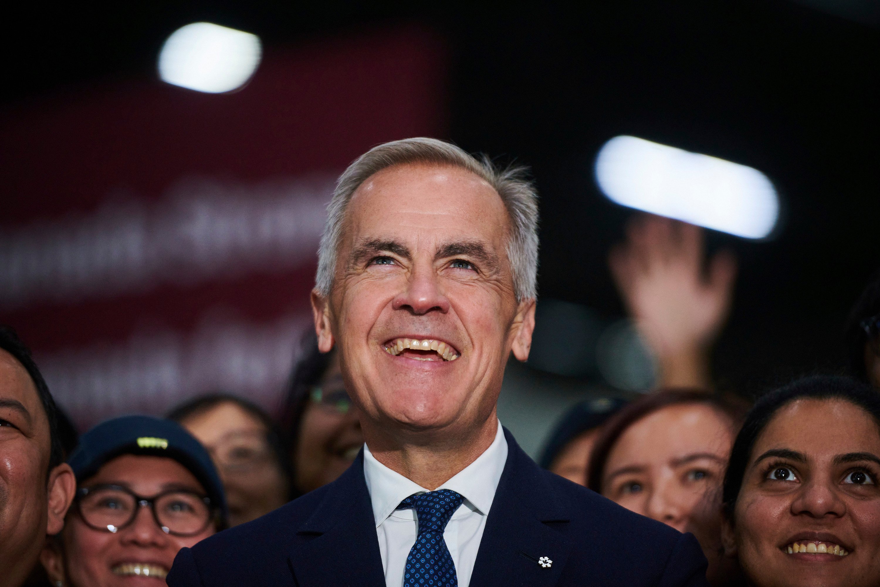 Canadian Prime Minister Mark Carney he takes photos with workers at a manufacturing facility in Mississauga, Ontario, on Friday. Photo: The Canadian Press via AP