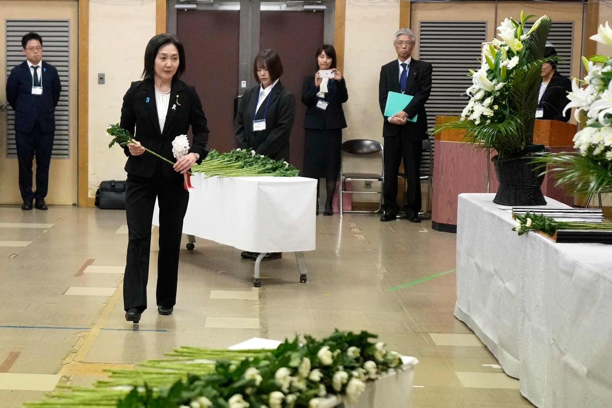Akiko Ikuina, vice-minister for foreign affairs, offers a flower on behalf of the government during a memorial ceremony for the Sado Island Gold Mine in Niigata prefecture, Japan, on November 24, 2024. Photo: AP