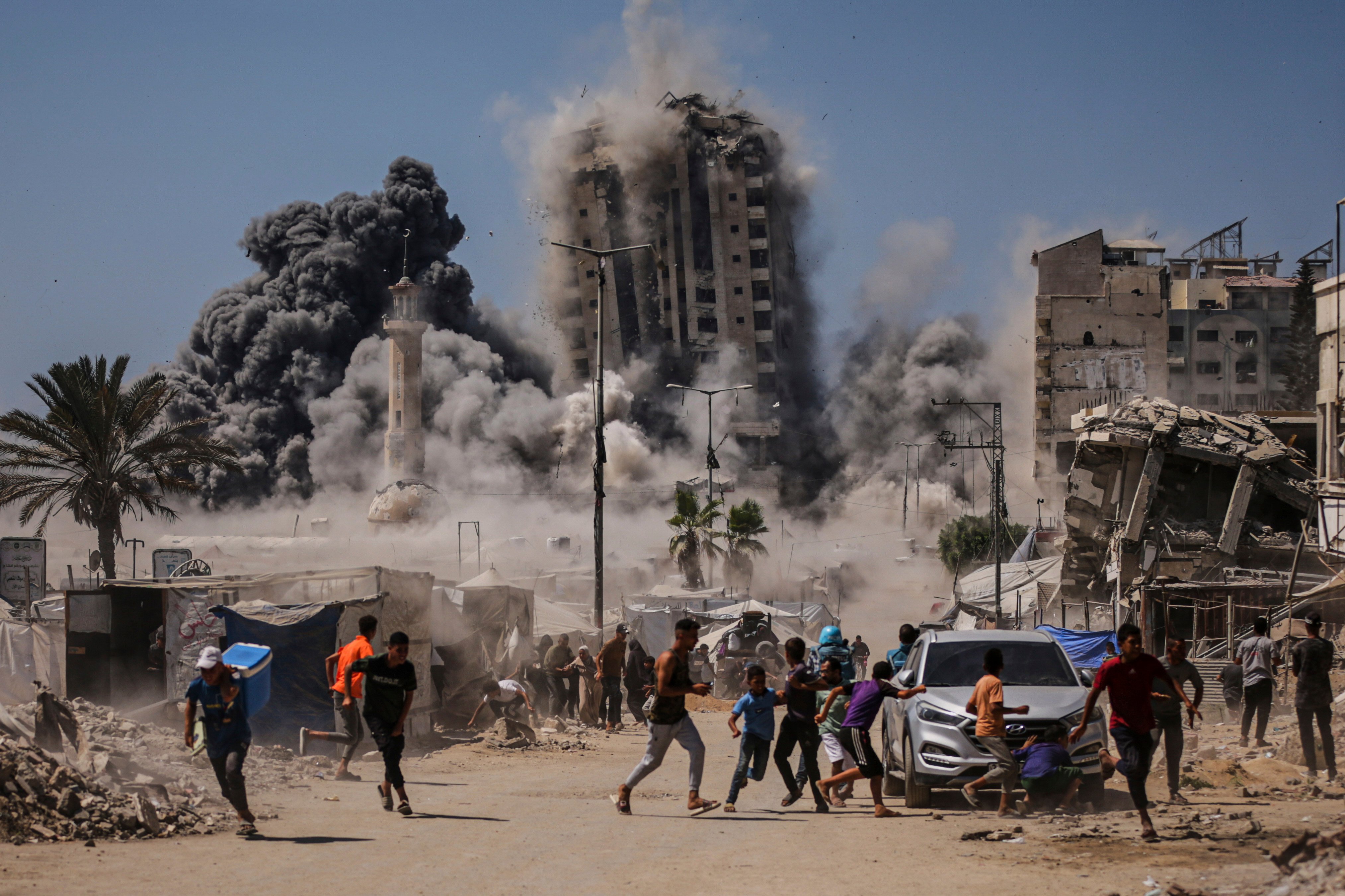 Palestinians run for cover during an Israeli airstrike on a building in Gaza City on Friday following an earlier warning by the Israeli army. Photo: AP