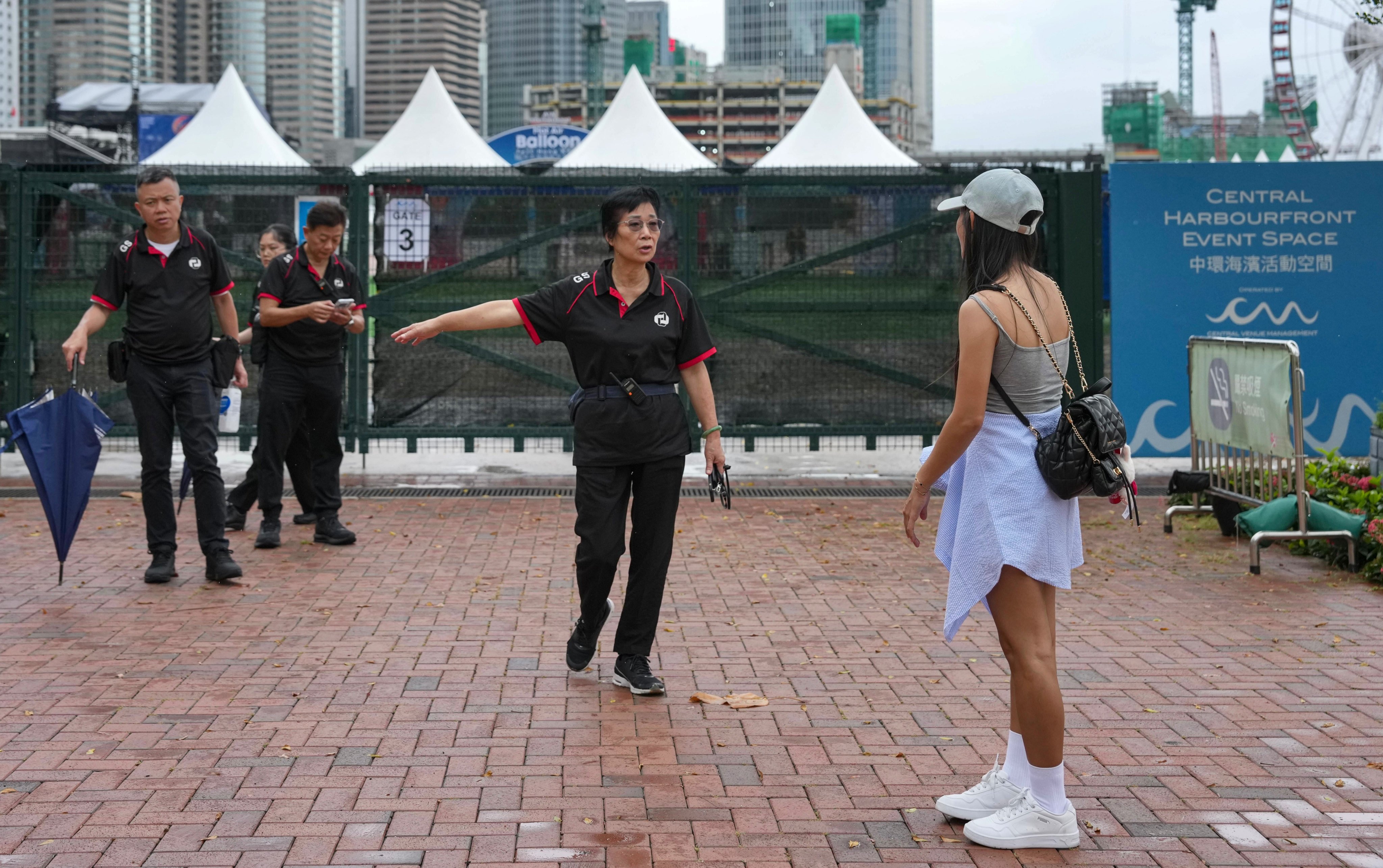 Security staff speak to a visitor at the AIA International Balloon Festival in Central  on Sunday morning. Photo: Karma Lo