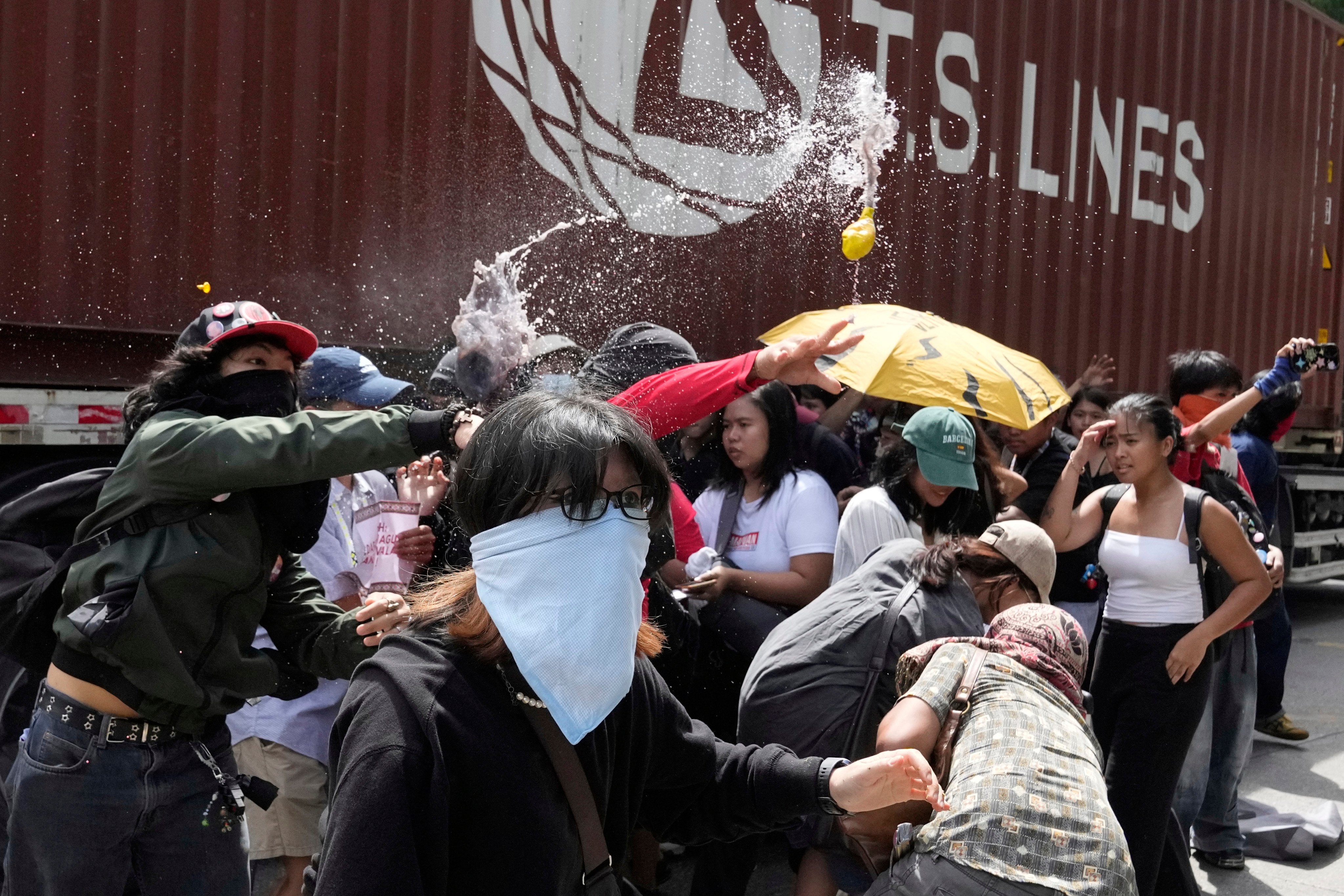 Protesters throw balloons filled with dirty water outside the Philippine Department of Public Works and Highways. Photo: AP