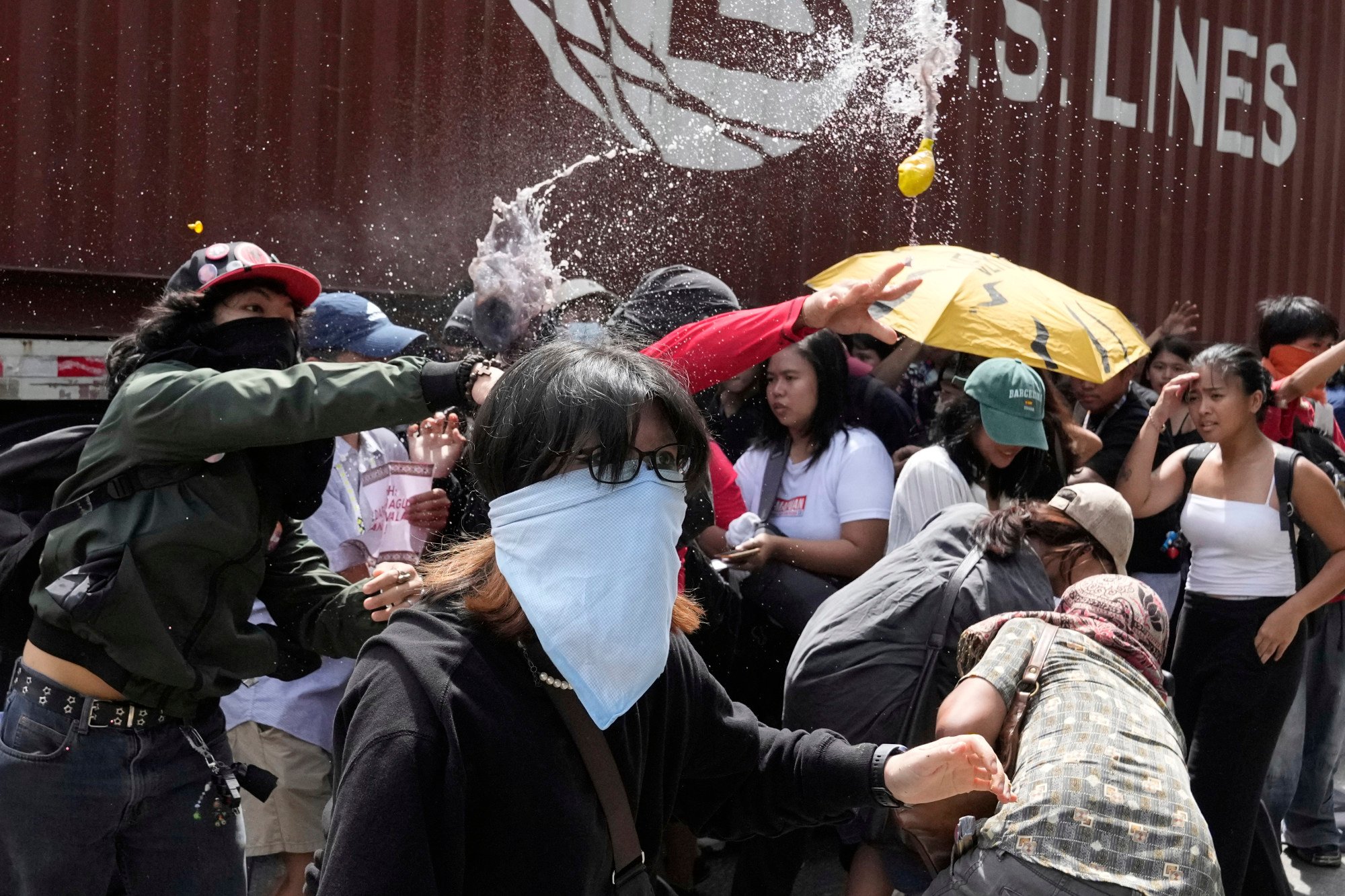 Protesters throw balloons filled with dirty water during a rally on Thursday outside the Philippines’ Department of Public Works and Highways. Photo: AP