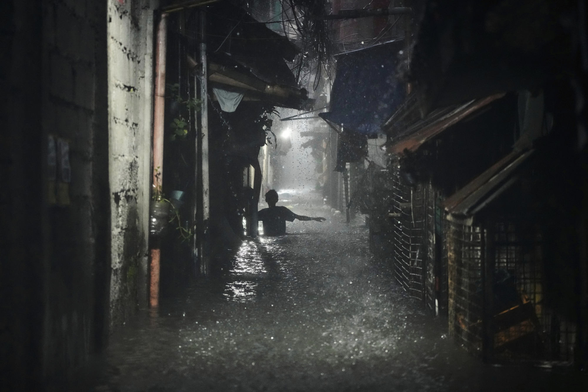 A man wades through waist-deep floodwaters in a residential area of Quezon City, the Philippines, on July 21. Photo: AP