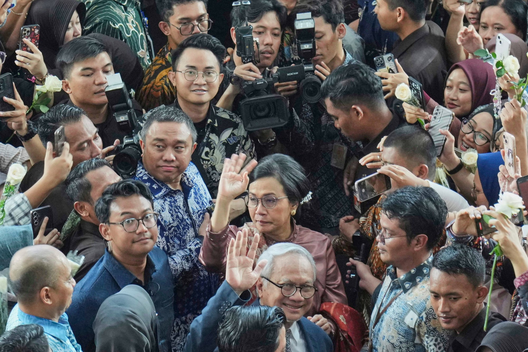 Outgoing Finance Minister Sri Mulyani Indrawati (centre) and her husband Tonny Sumartono (bottom) wave as they leave a handover ceremony to her successor on Tuesday in Jakarta. Photo: AP