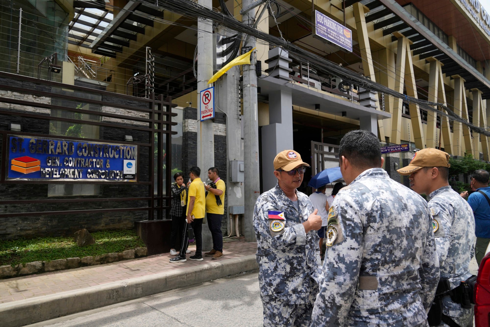 Members of the Philippine Coast Guard monitor the office of a firm owned by controversial contractors Sarah and Curlee Discaya in Pasig city on September 2. Photo: AP