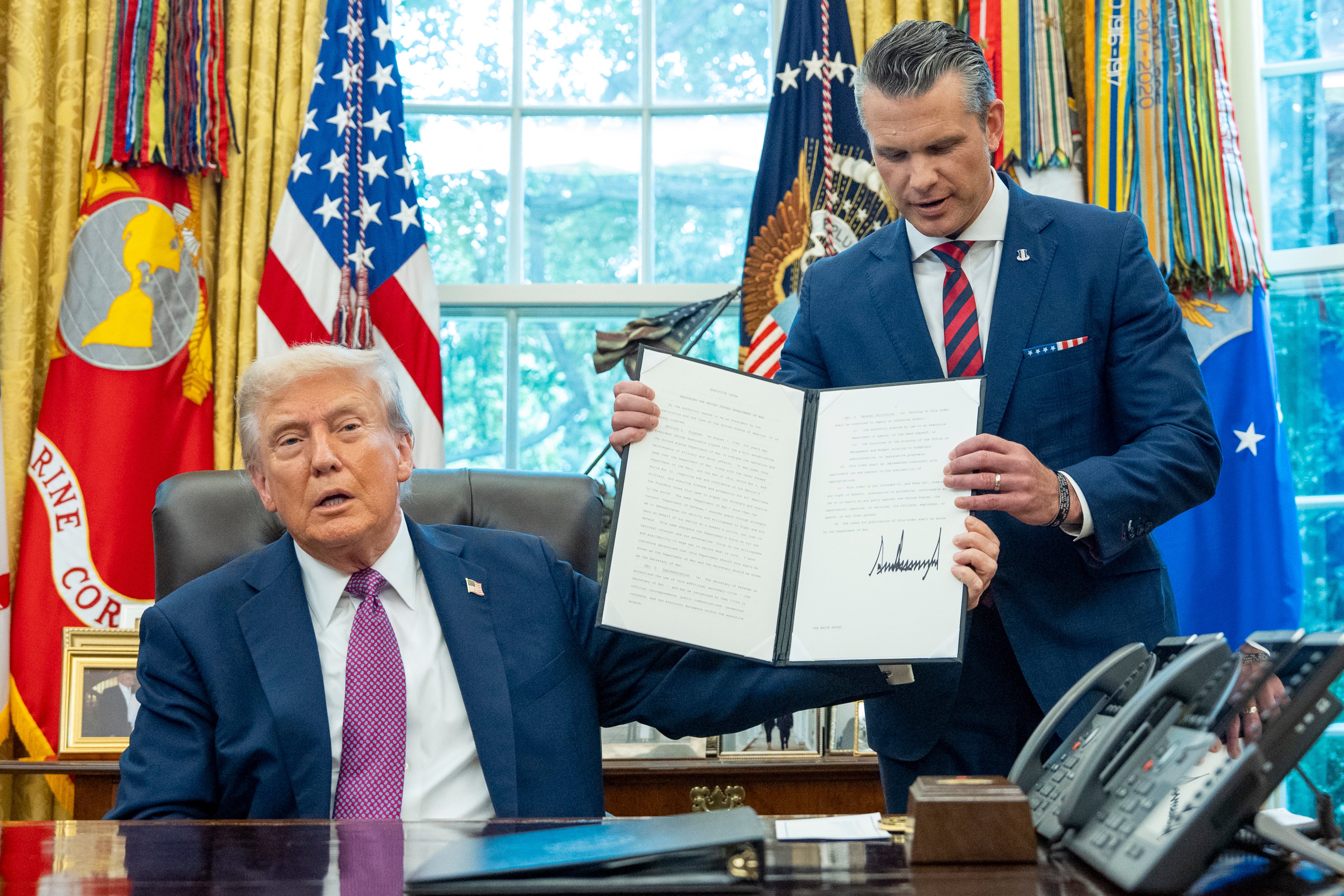 US President Donald Trump hands a signed executive order to Defense Secretary Pete Hegseth renaming the Department of Defence as the Department of War in the Oval Office of the White House on September 5, 2025. An arm of the government dedicated to war also existed in imperial China. Photo: AP