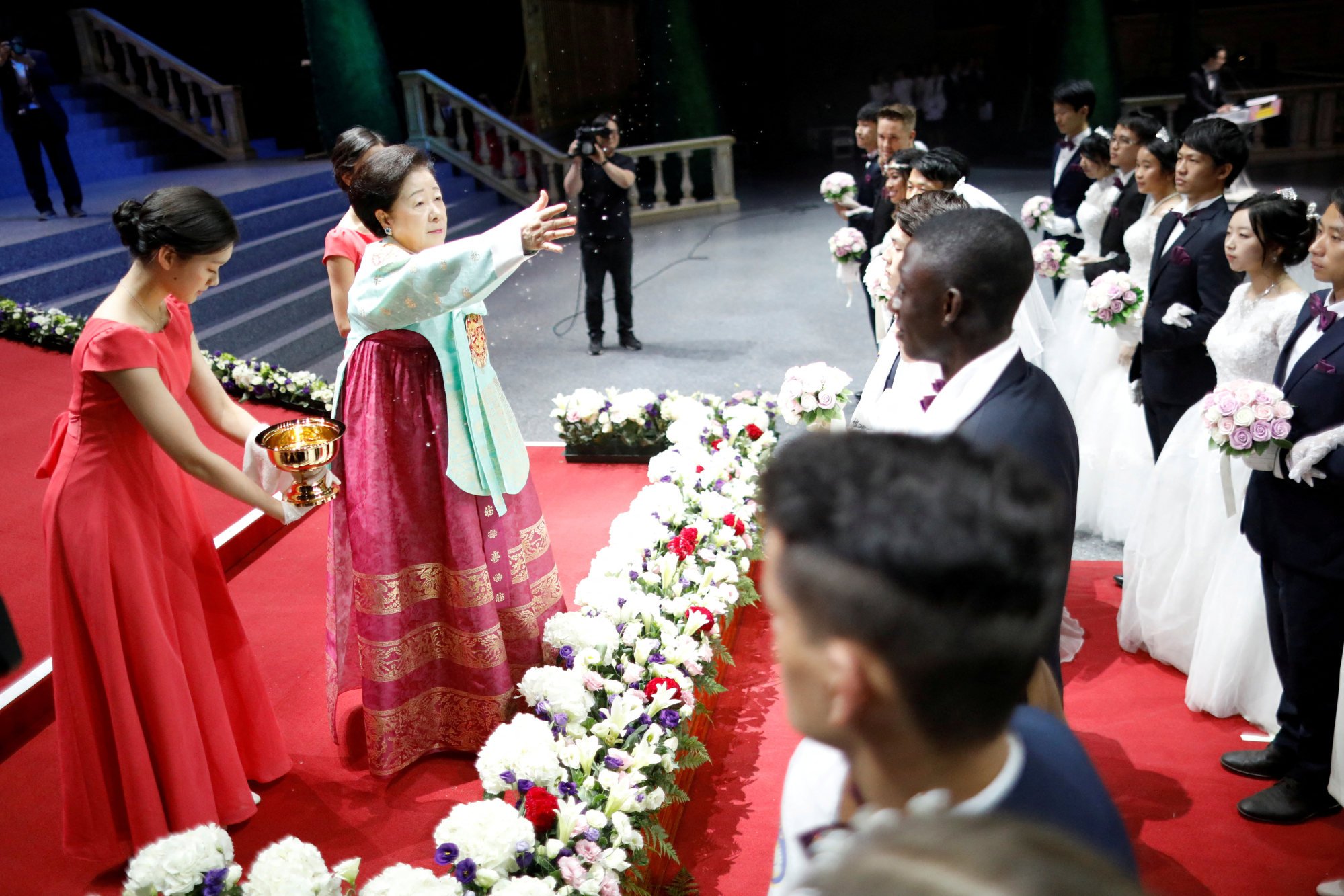 Han Hak-ja (second from left) sprays holy water to bless couples during a mass wedding ceremony at the Unification Church’s Cheongshim Peace World Centre in Gapyeong, South Korea, in 2018. Photo: Reuters
