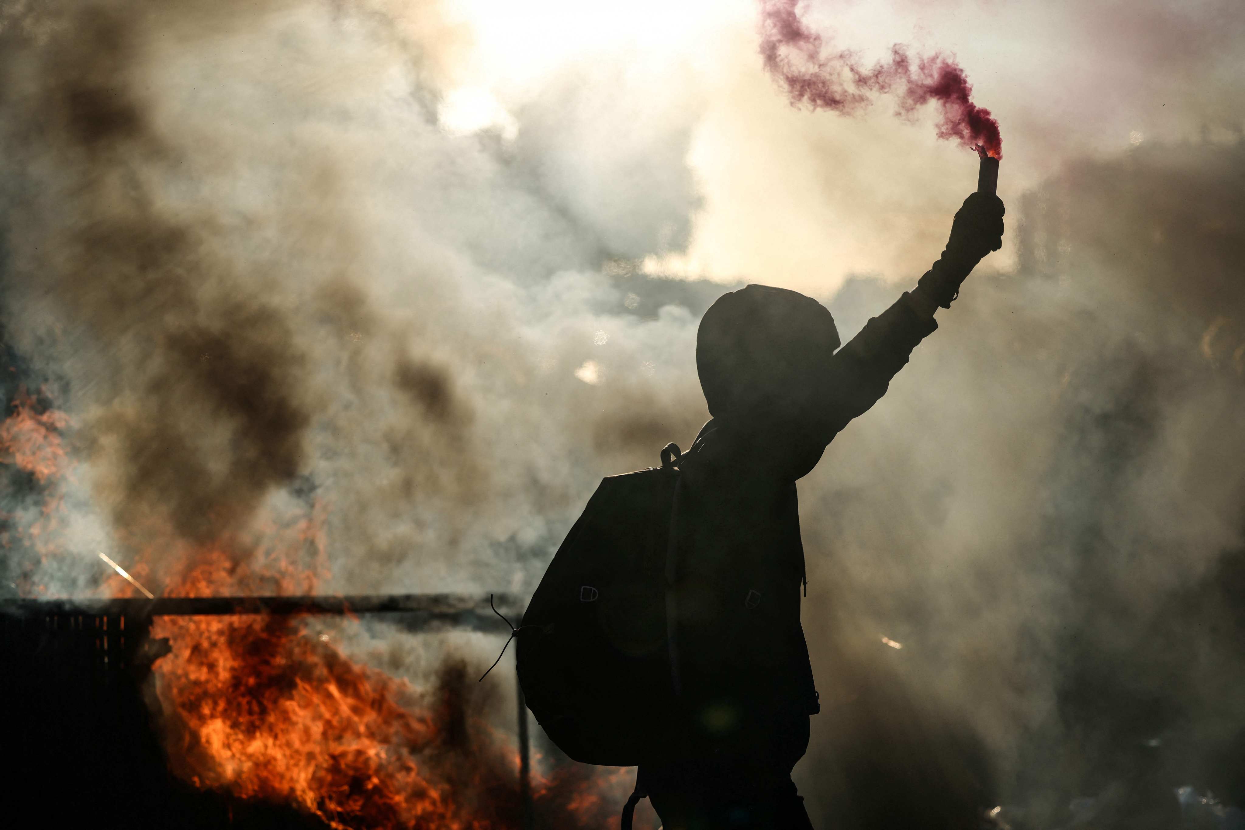 A protester brandishes a flare during the “Bloquons Tout”, or “Block Everything”, protests on Wednesday. Photo: AFP