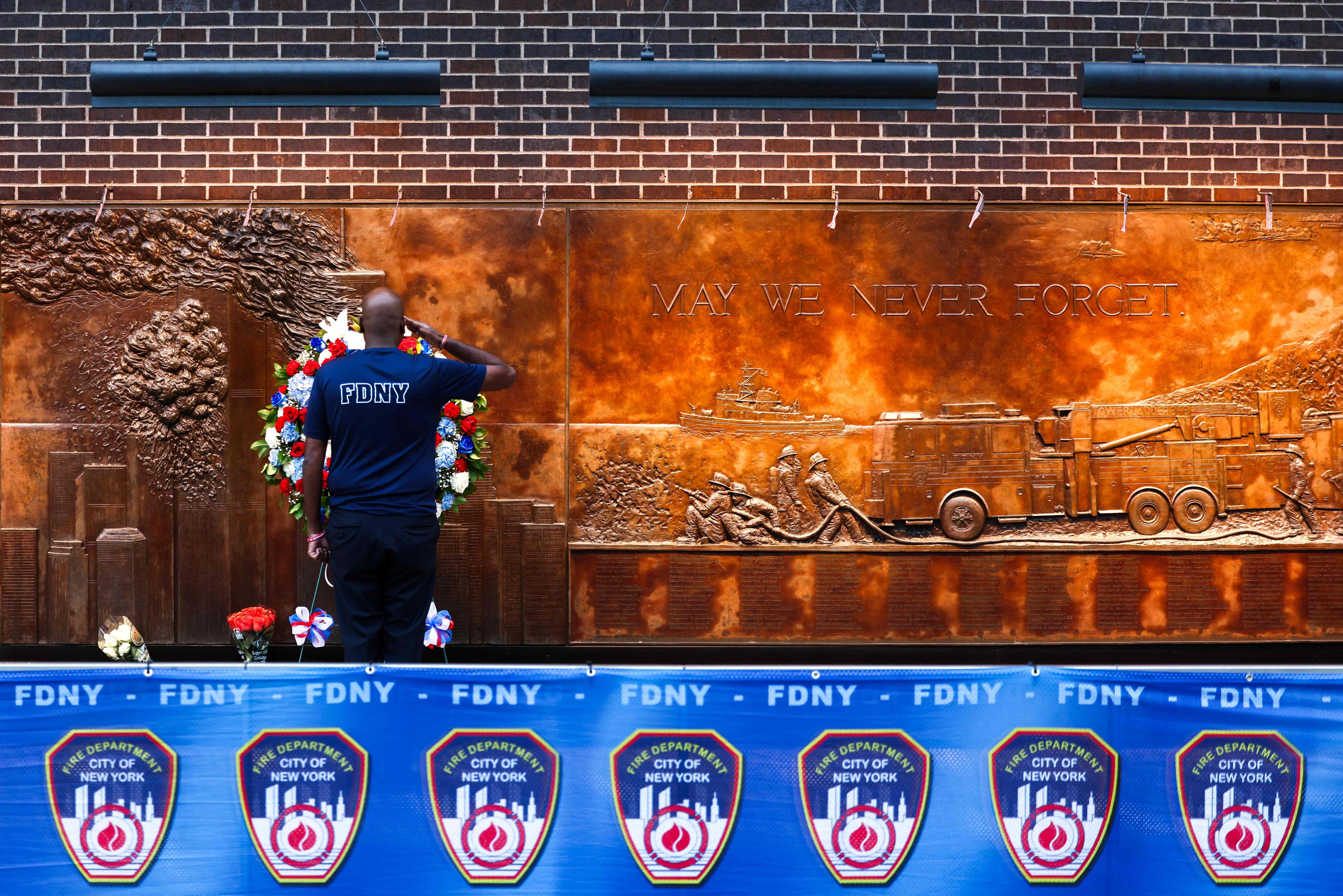 A firefighter stands in tribute in front of a FDNY memorial wall in the World Trade Centre area ahead of the 24th anniversary of the September 11 terror attacks ceremony, in New York on Thursday. Photo: AFP