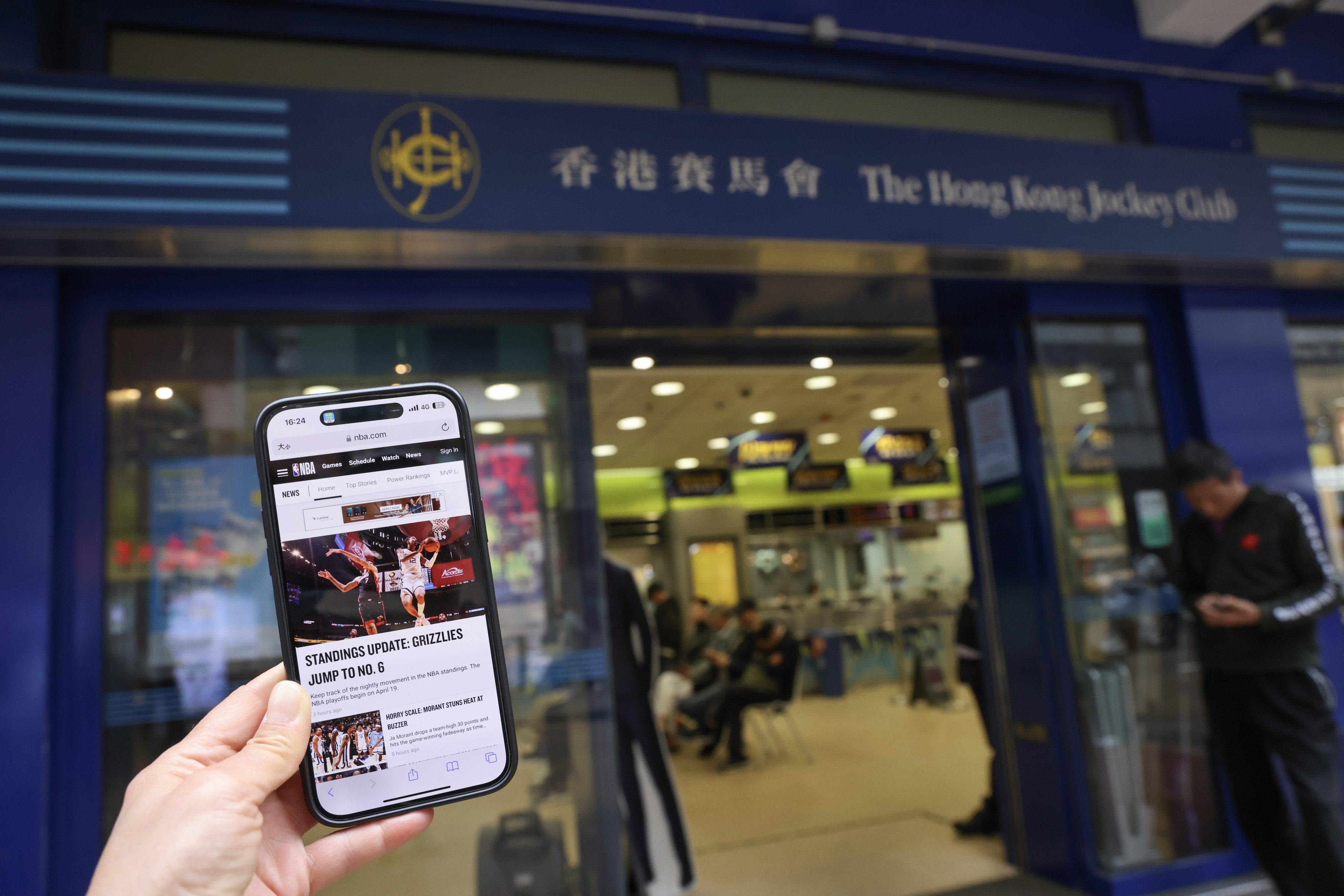 A screenshot of the NBA news website is juxtaposed with the Hong Kong Jockey Club betting branch in Mong Kok, on April 4. Photo: Jelly Tse