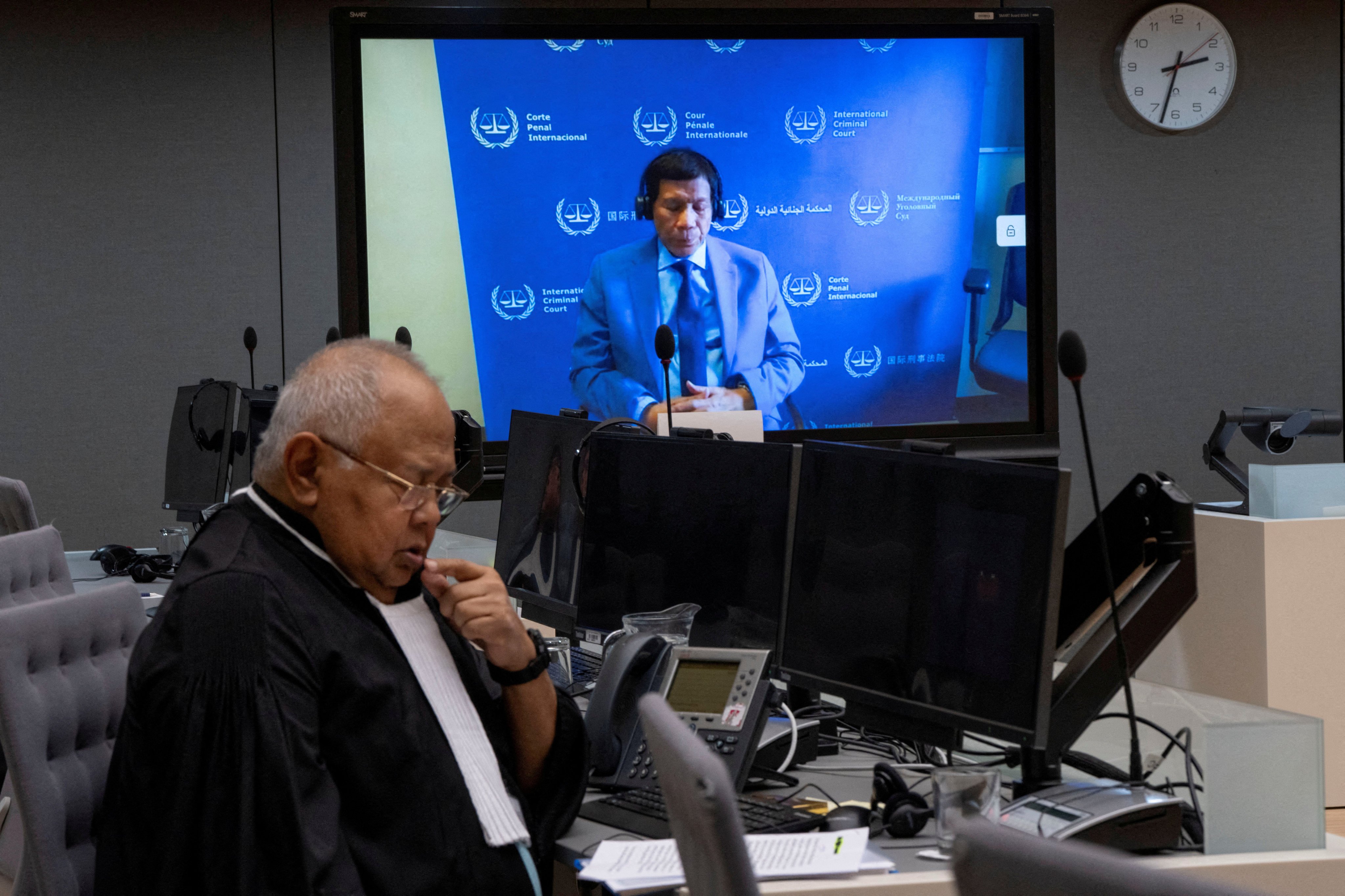 Former Philippine president Rodrigo Duterte is seen on a screen in the courtroom of the International Criminal Court with his lawyer Salvador Medialdea seated left, in The Hague, Netherlands, on March 14. Photo: Pool via Reuters