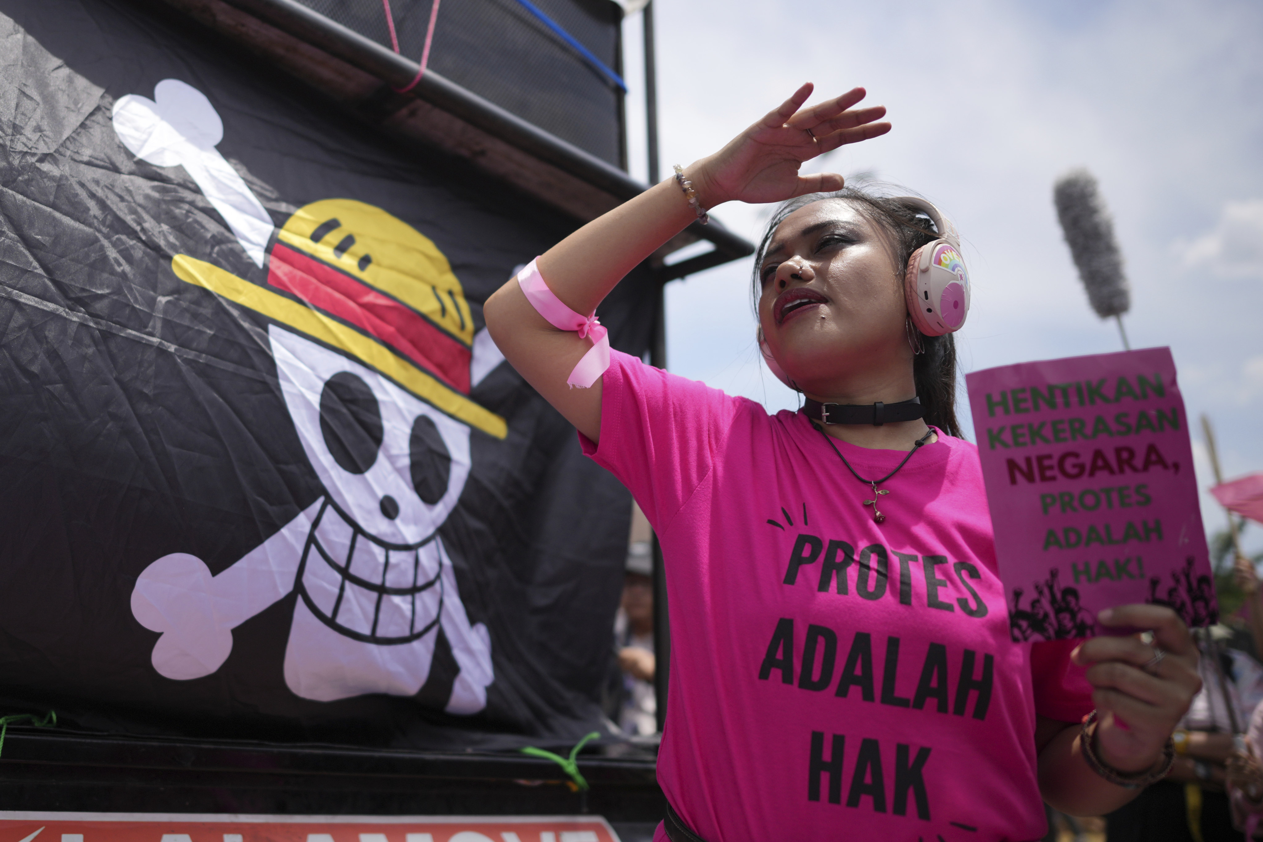 An activist holds a poster as a flag from the Japanese anime One Piece is displayed during a rally in Jakarta, Indonesia, on September 3, 2025. Photo: AP