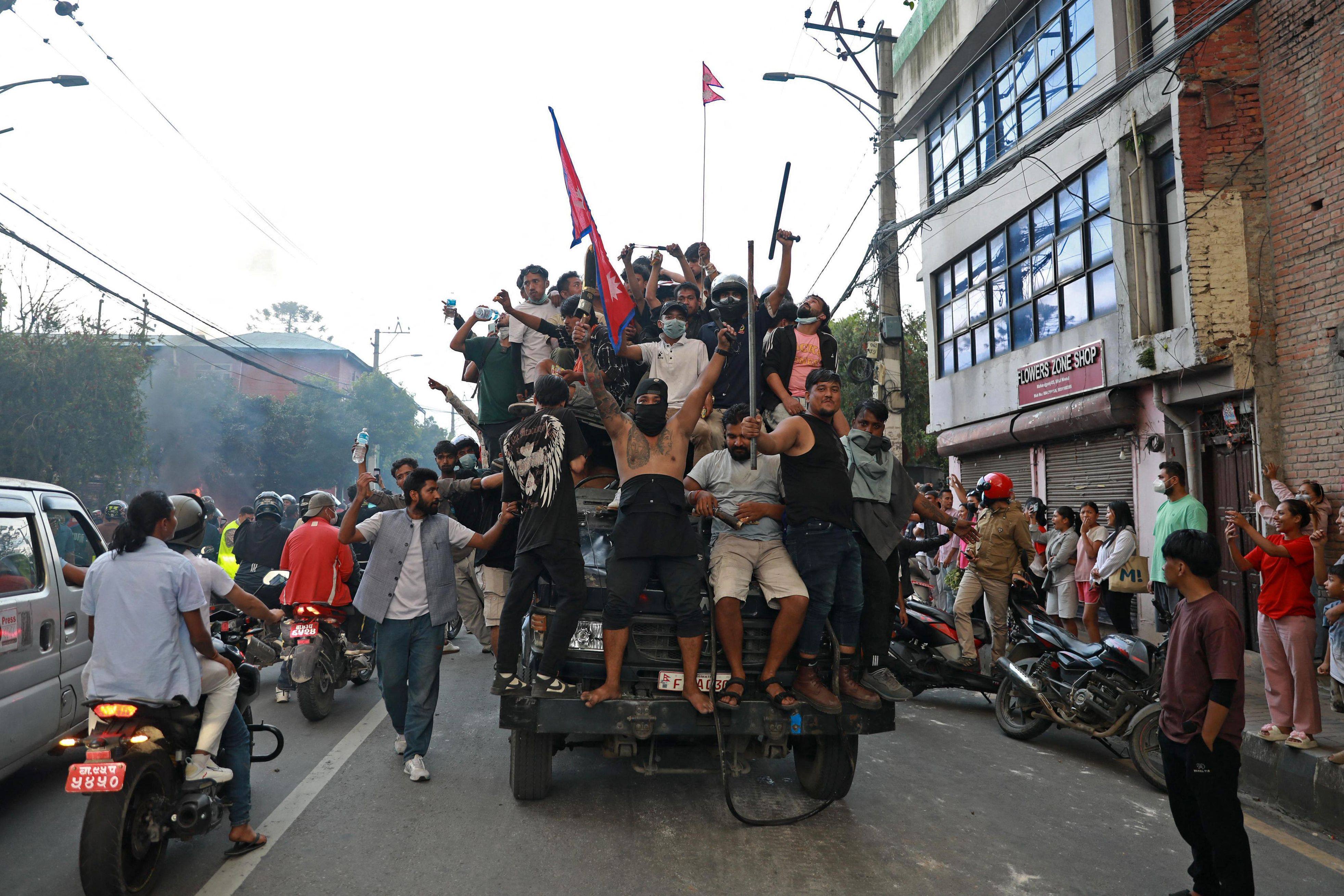 Protesters ride a police truck in Kathmandu, Nepal, on Tuesday. Photo: AFP