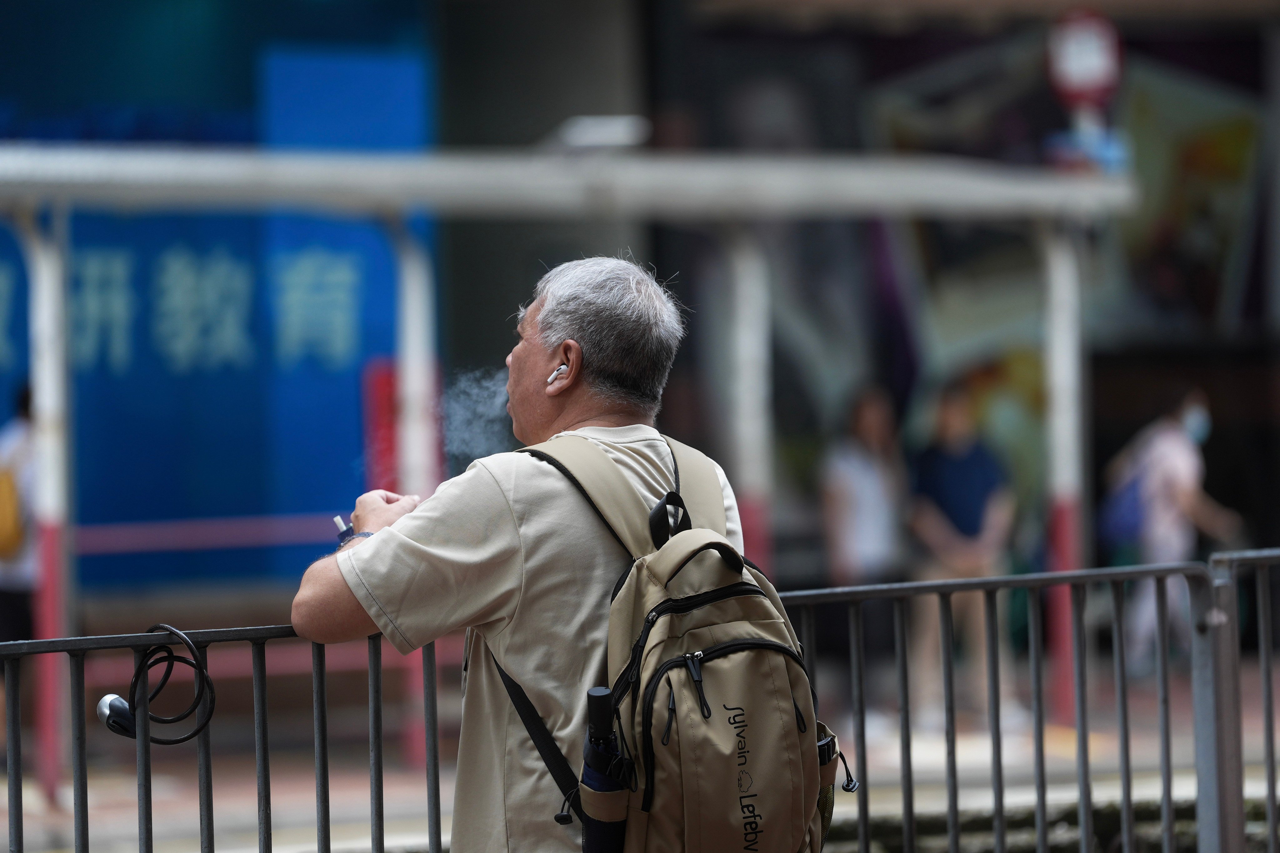 A man vapes in the street near a bus stop at Hang Hau. Photo: Elson Li