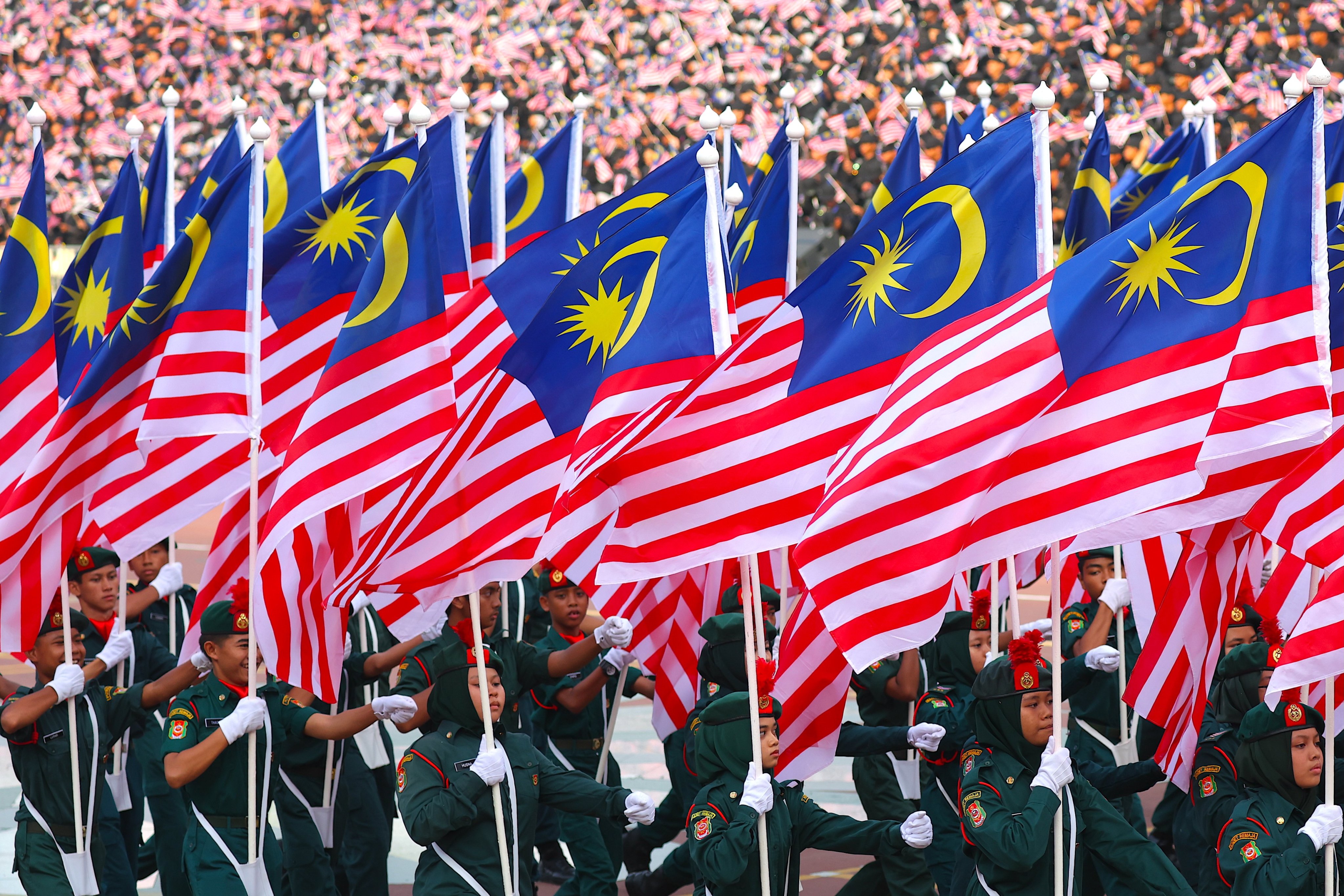 Participants hold Malaysia’s national flag during National Day celebrations in Putrajaya on August 31. Photo: EPA
