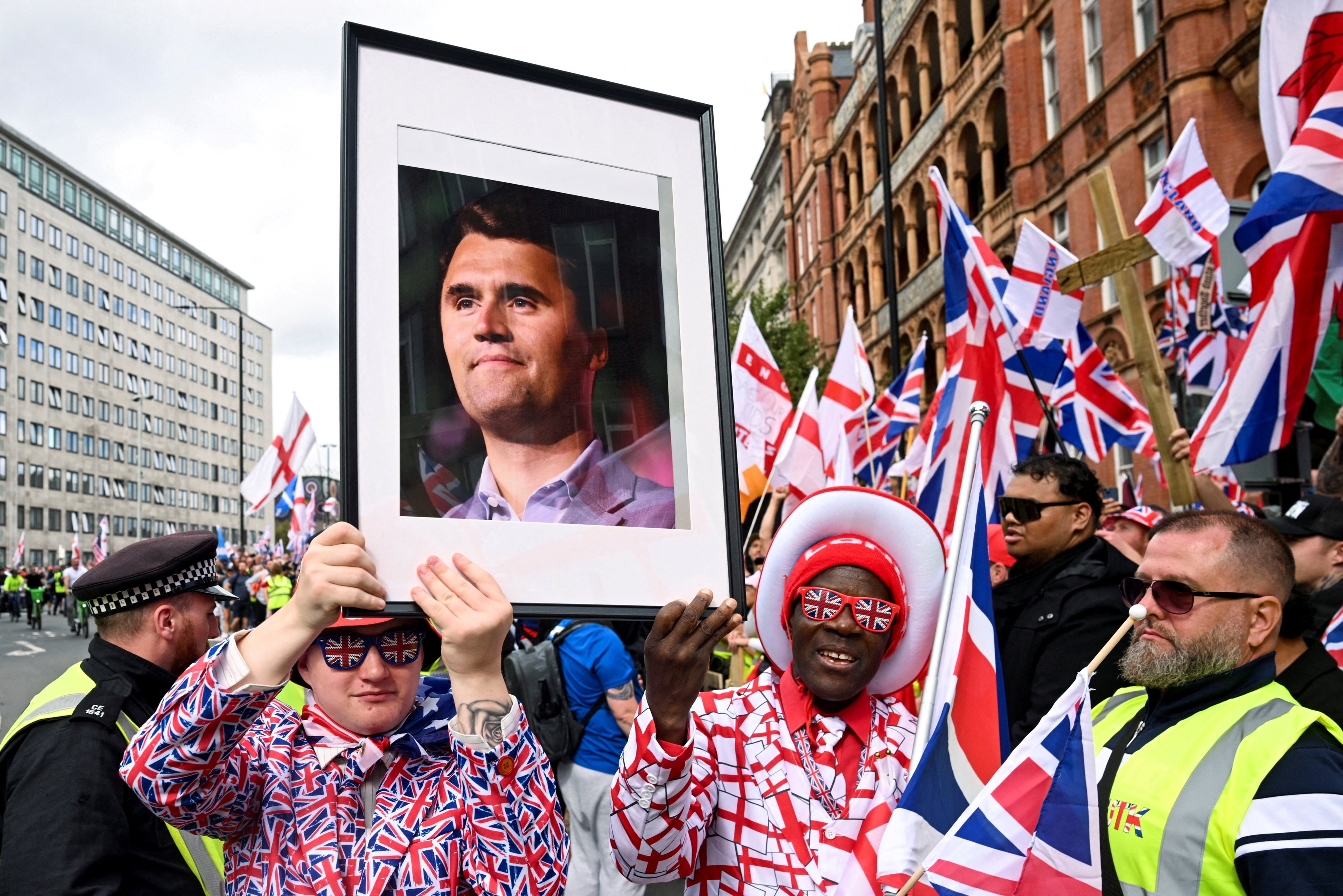 Protesters hold a picture of US conservative activist Charlie Kirk, who was fatally shot while speaking in Utah, at an anti-immigration rally in London on Saturday. Photo: Reuters