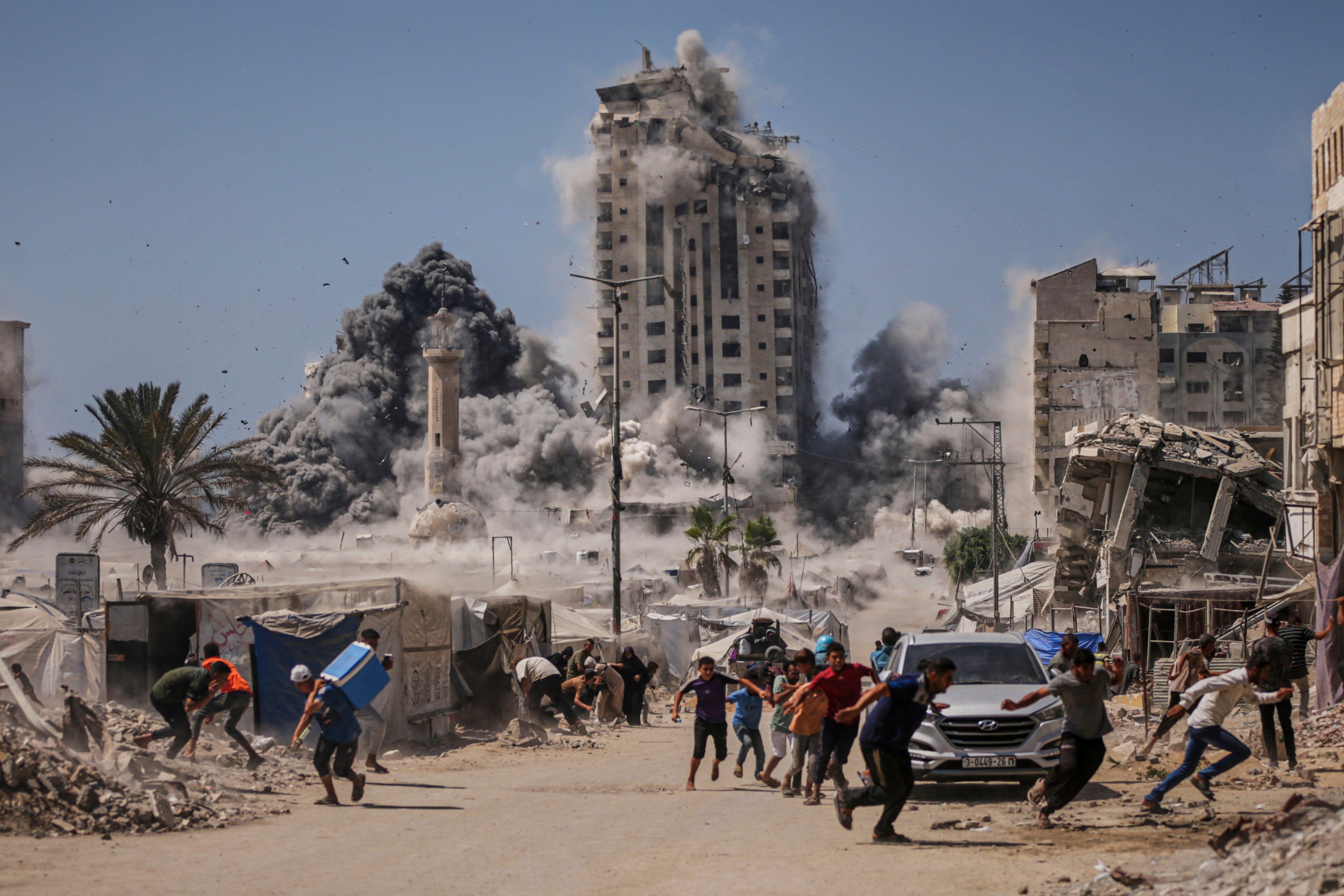 Palestinians run for cover during an Israeli air strike on a building in Gaza City on September 5. Photo: AP