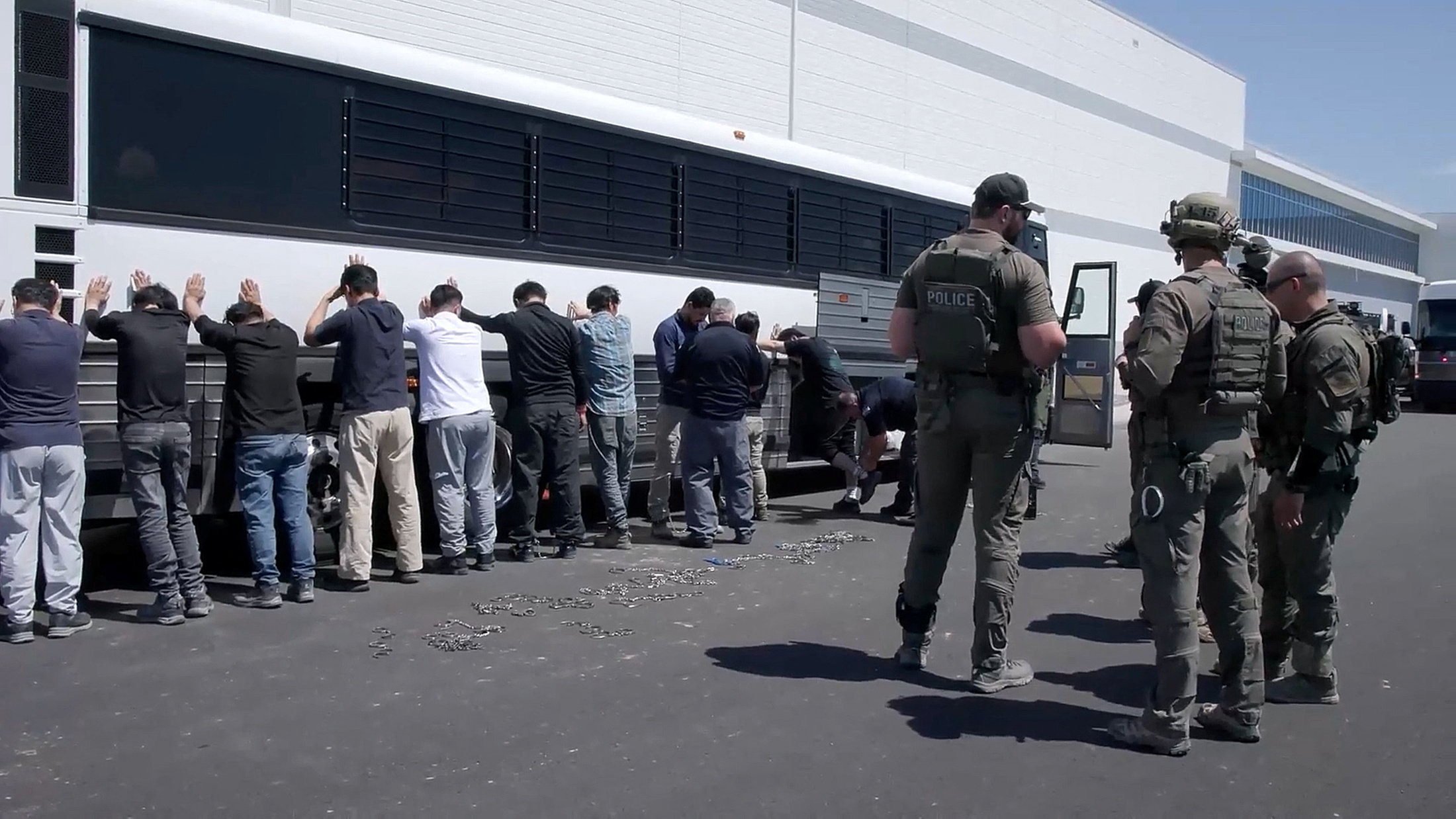 Detainees are made to stand against a bus before being handcuffed, during a surprise raid on September 4 at HL-GA Battery Company near Savannah, Georgia. Photo: US Immigration and Customs Enforcement/Handout via Reuters