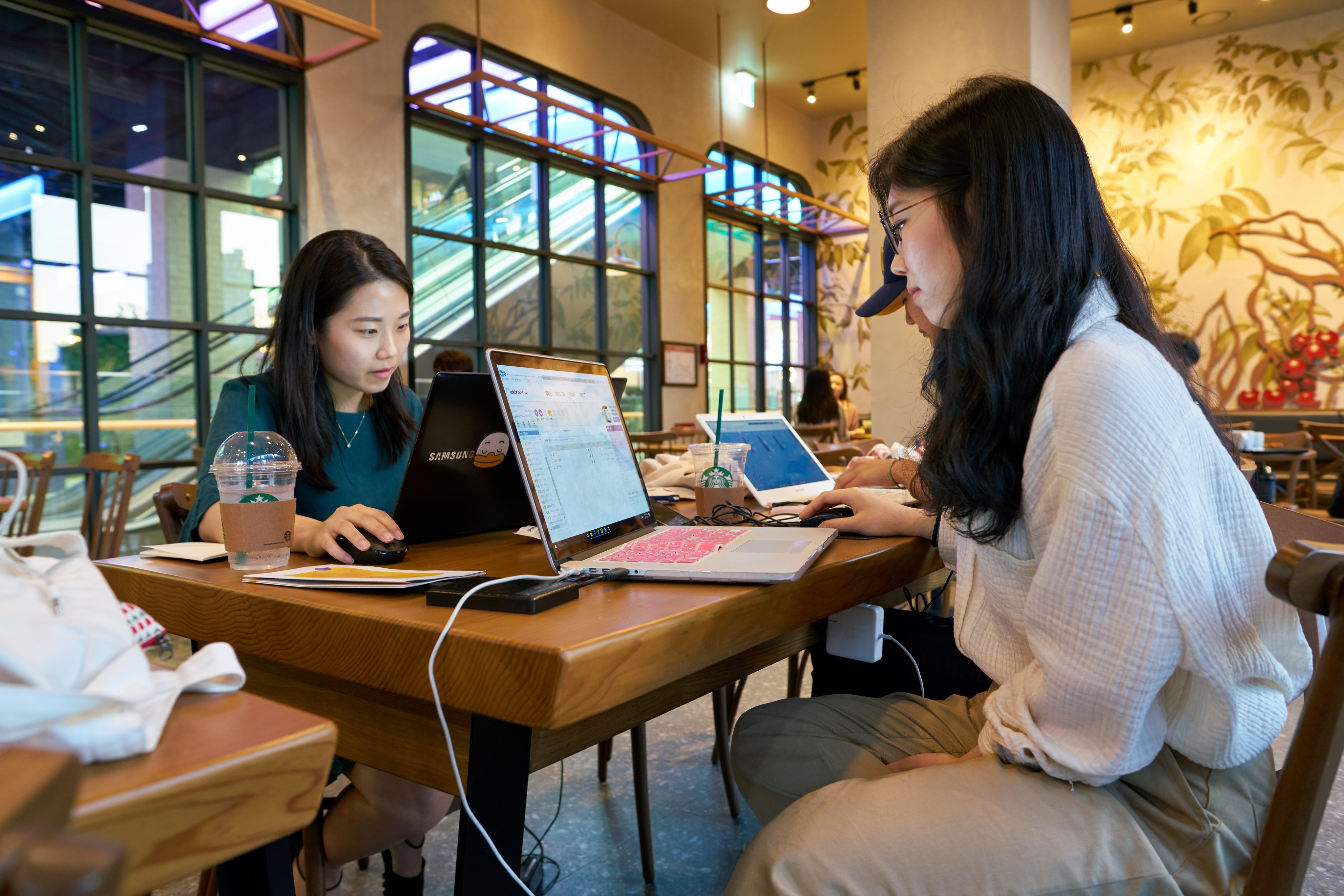 People use their laptops at a Starbucks in Seoul. Too many cafes like this are filled with digital nomads who nurse a single coffee for hours on end, Charmaine Mok says. Photo: Shutterstock