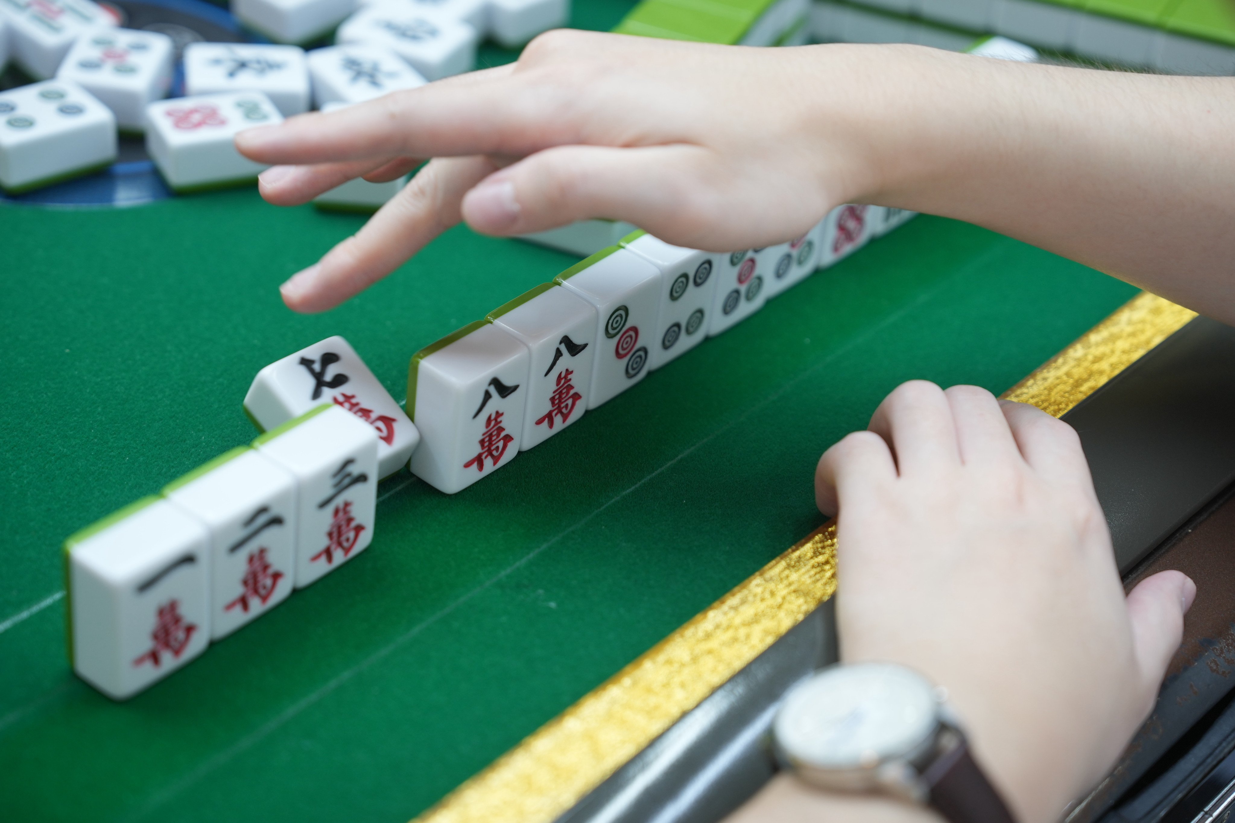 A player discards a tile during a session at the Hong Kong Mahjong Company. Photo: May Tse