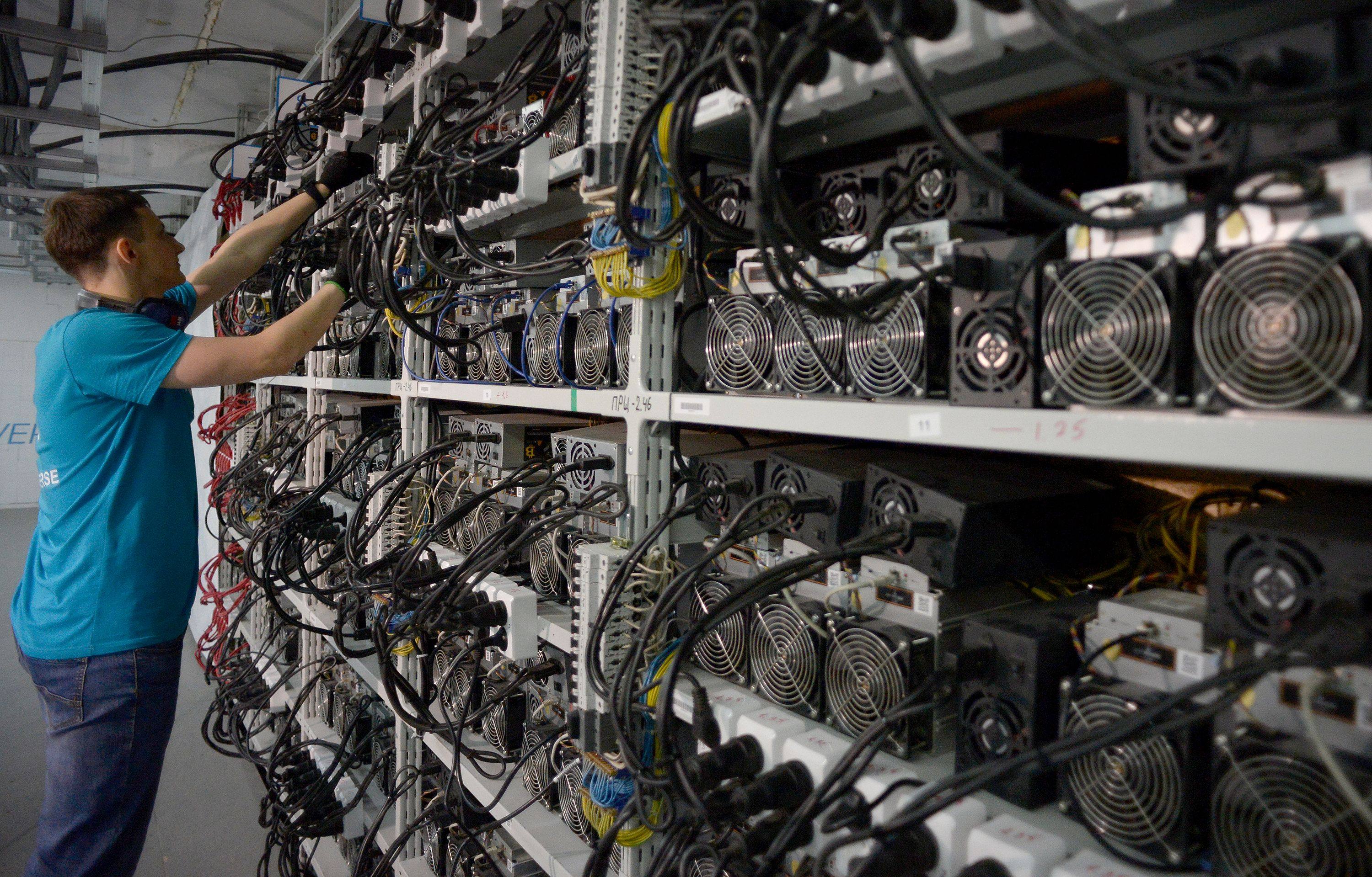 A man checks machines used for cryptocurrency mining. Photo: AFP