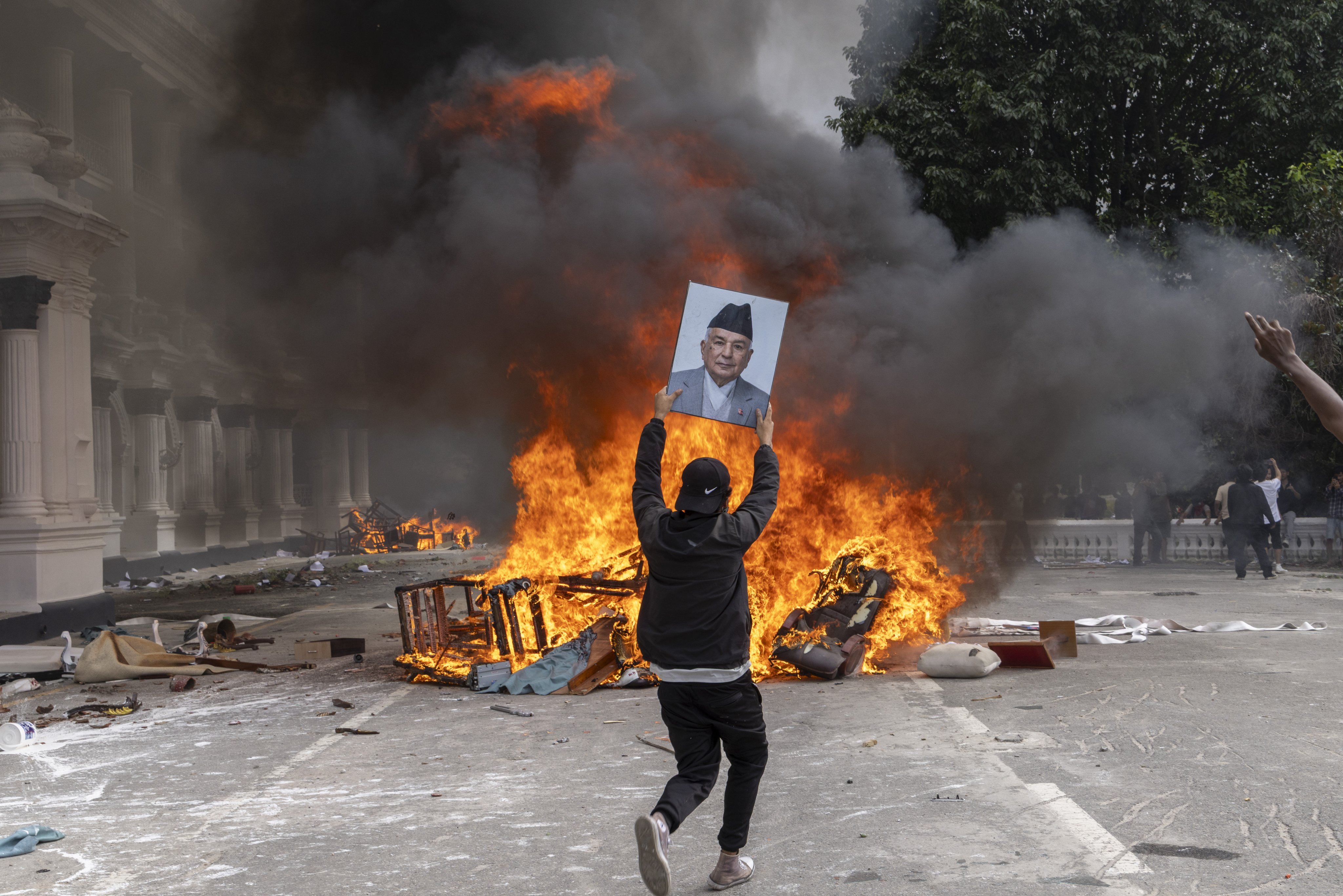 A protester storms the Singha Durbar palace, which houses government and parliament buildings, during violent demonstrations in Kathmandu on September 9. The protests reportedly led to more than 70 deaths. Photo: EPA