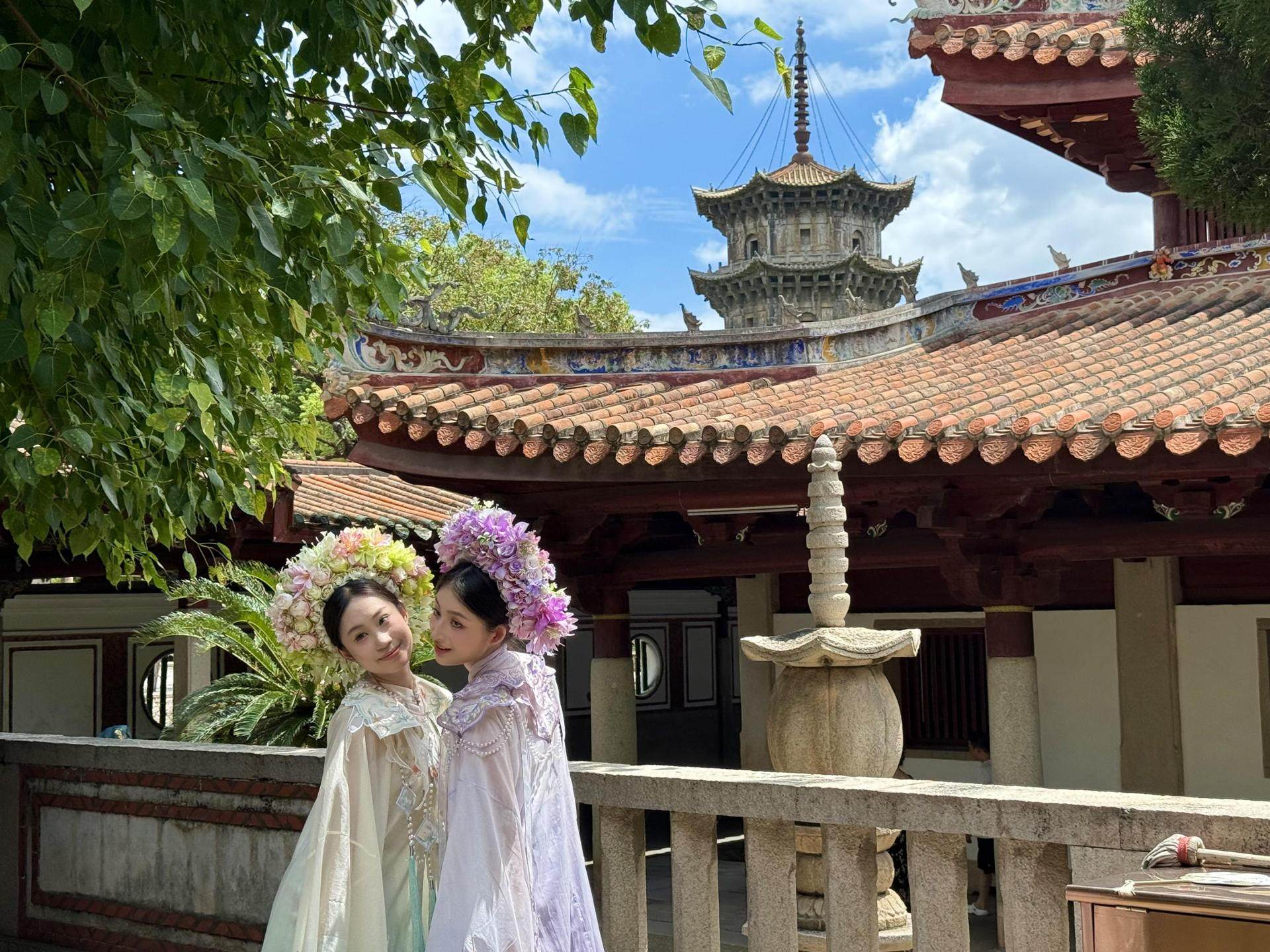 Travellers dressed in traditional garb pose at Kaiyuan Temple in Quanzhou, China. The city enchants visitors with its history and culture. Photo: The Korea Times