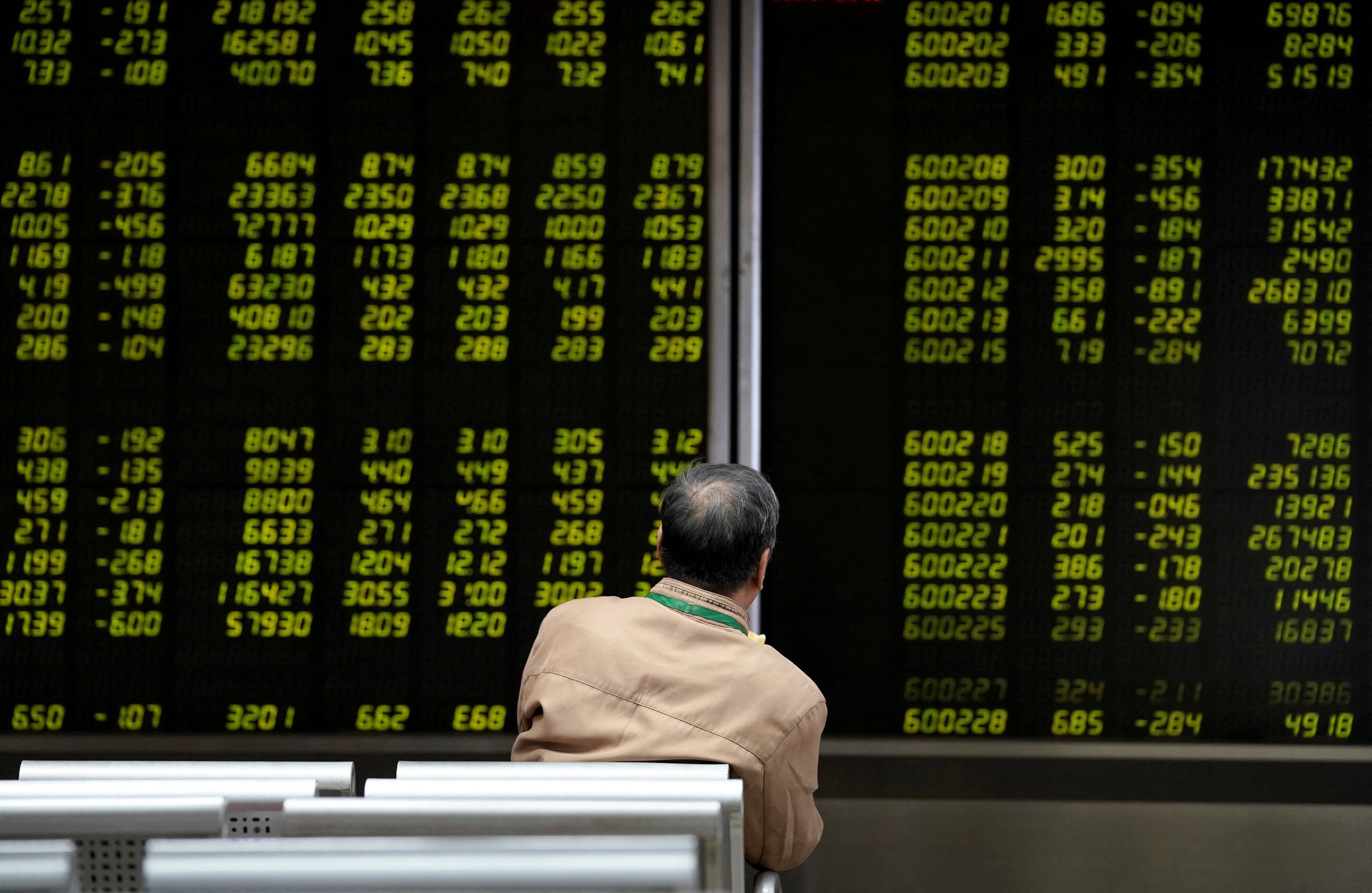 An investor watches a board showing stock information at a brokerage office in Beijing, China, on October 8, 2018. Photo: Reuters