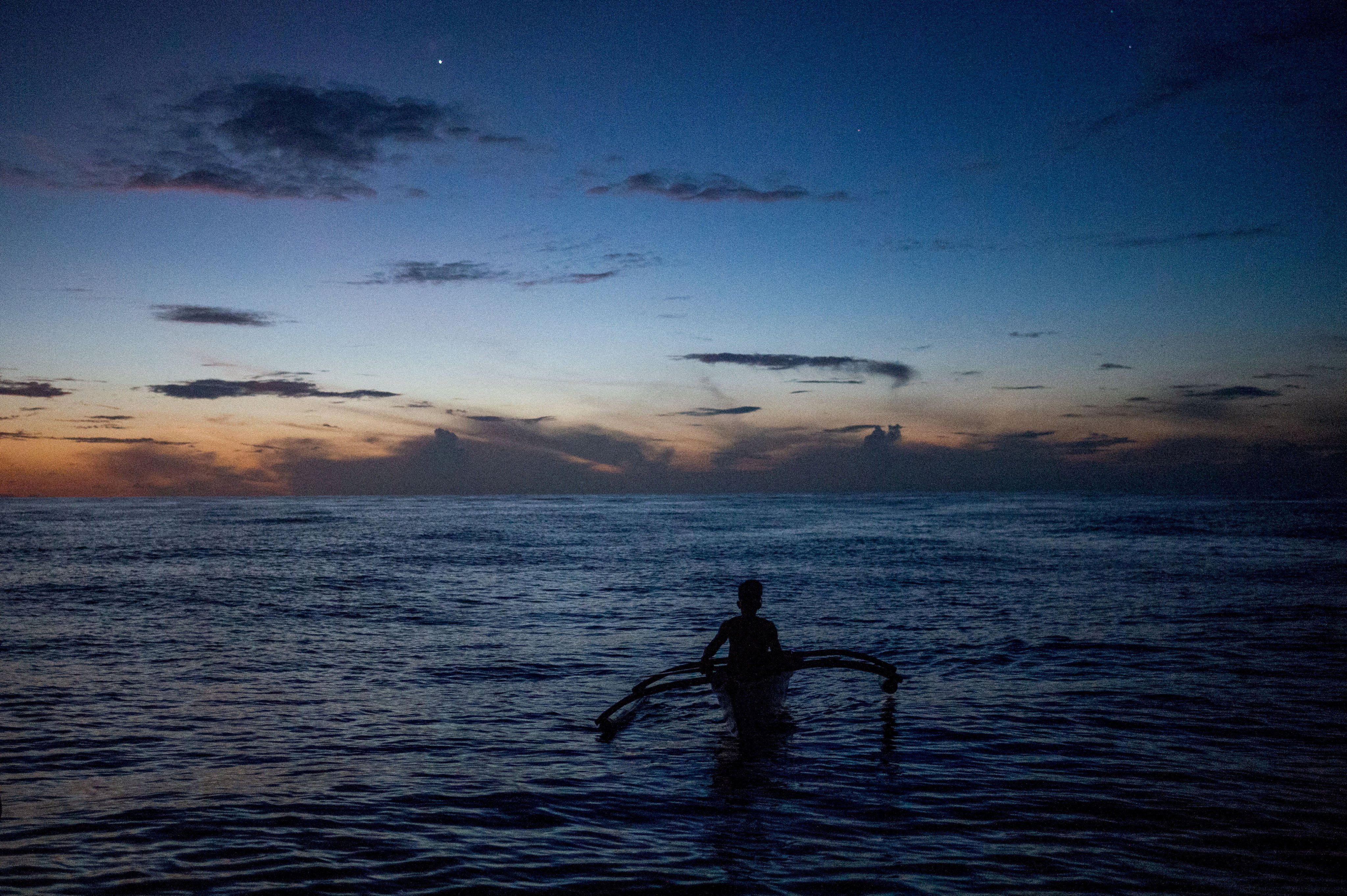 A Filipino fisheman rows his boat near the disputed Scarborough Shoal in the South China Sea, Photo: Reuters