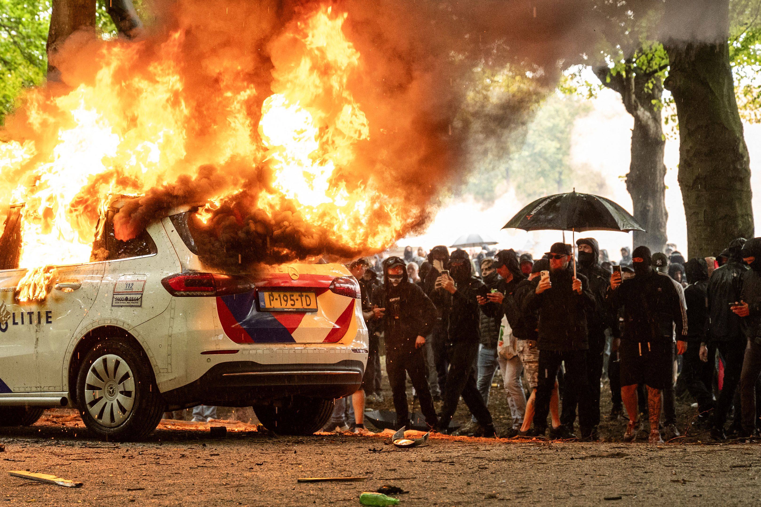 A police car is set on fire during the “Stand up for the Netherlands” demonstration in The Hague on Saturday. Photo: AFP
