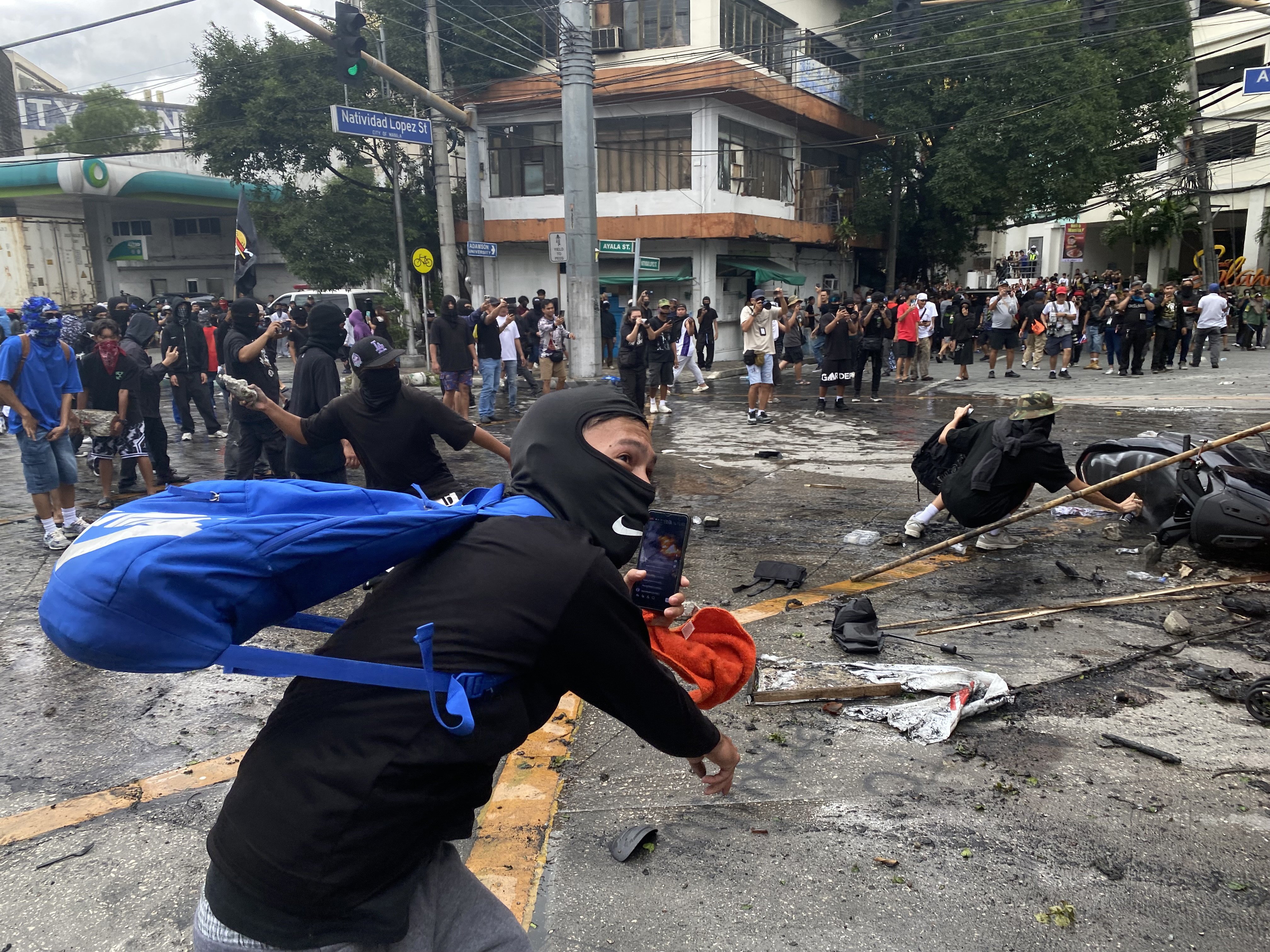 Protesters scuffle with anti-riot police in Manila on Sunday. Photo: EPA
