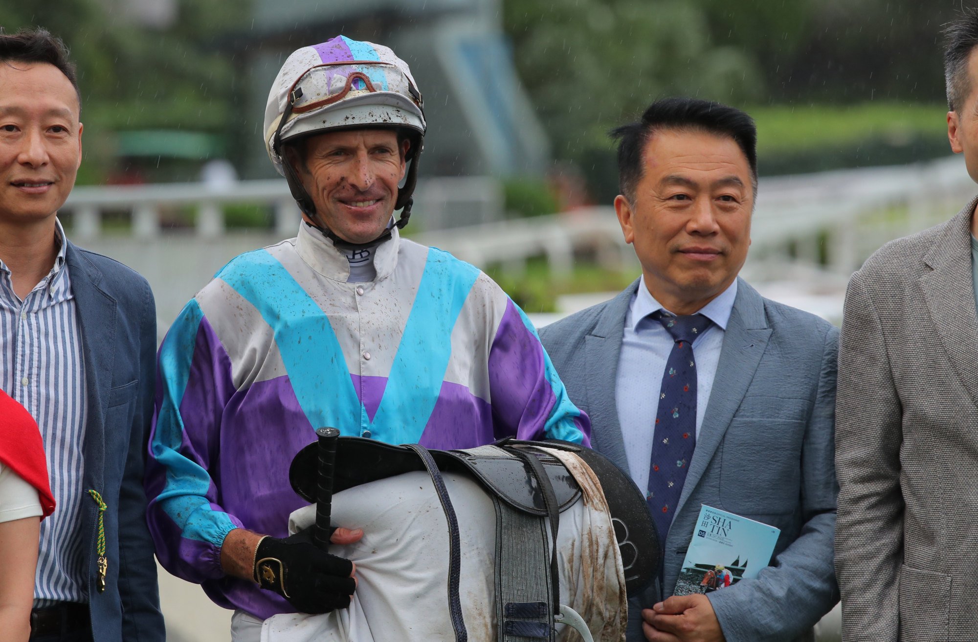 Jockey Hugh Bowman celebrates Solid Win’s victory with trainer Ricky Yiu and connections.