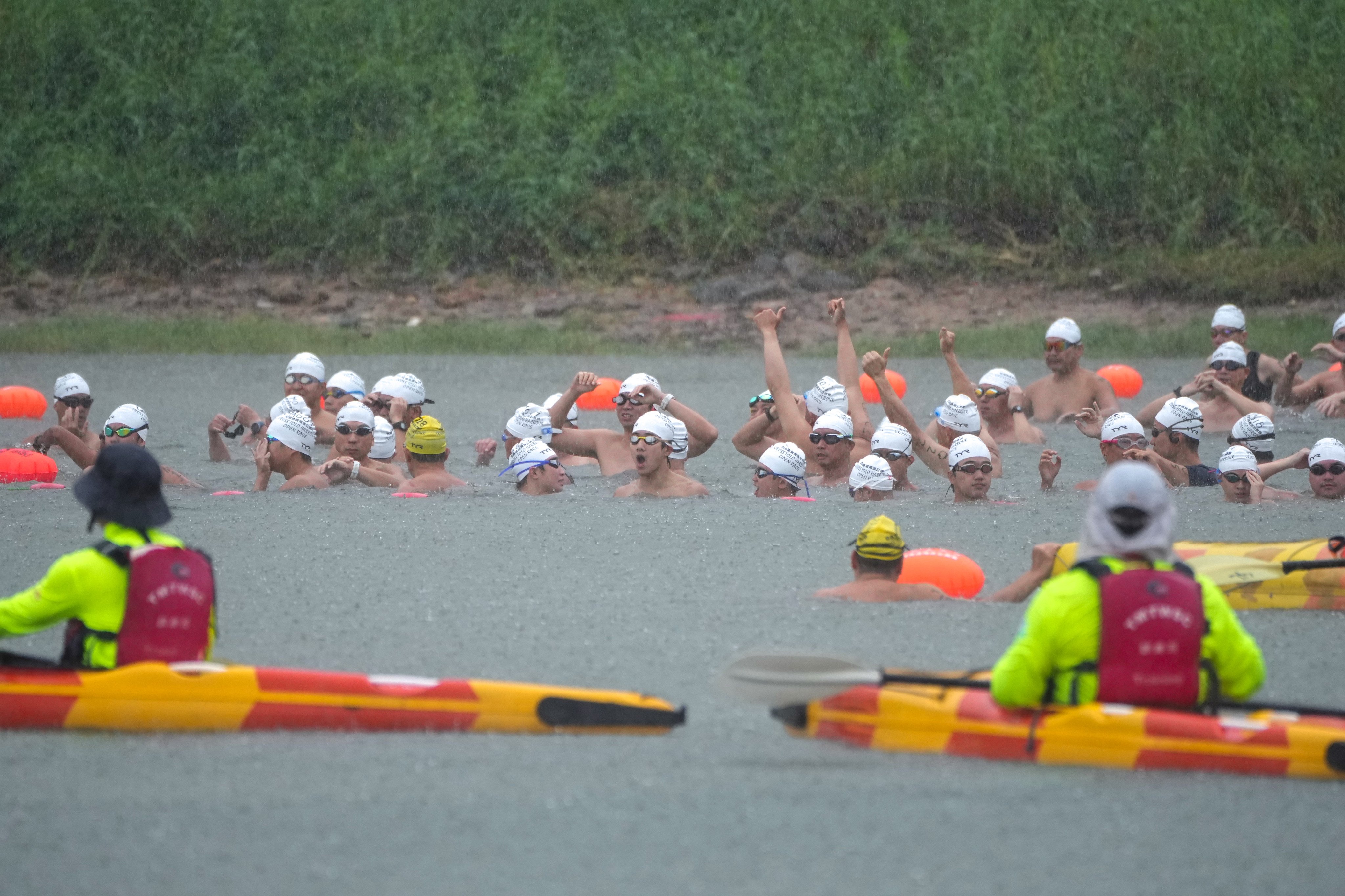 Swimmers participate in the Tolo Harbour race in the rain on Sunday. Photo: Sam Tsang
