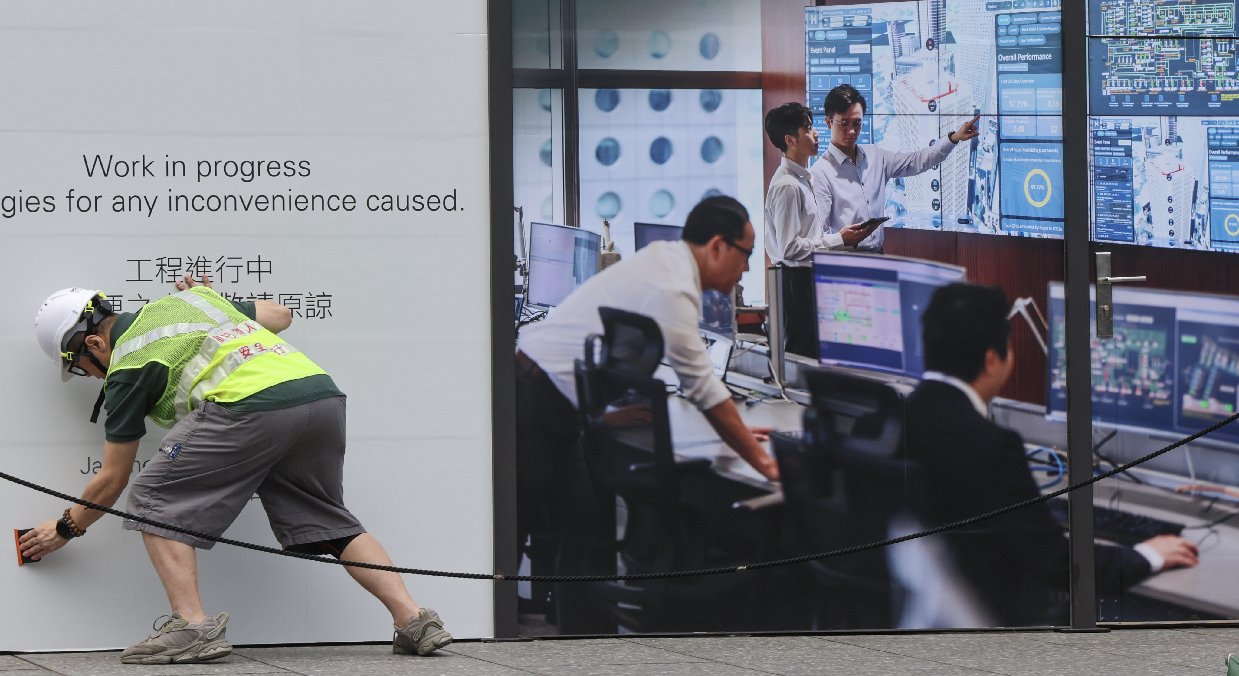 A worker smooths down a poster outside Jardine House in Central. City leader John Lee has stressed the need for flexibility in the labour import scheme. Photo: Jelly Tse