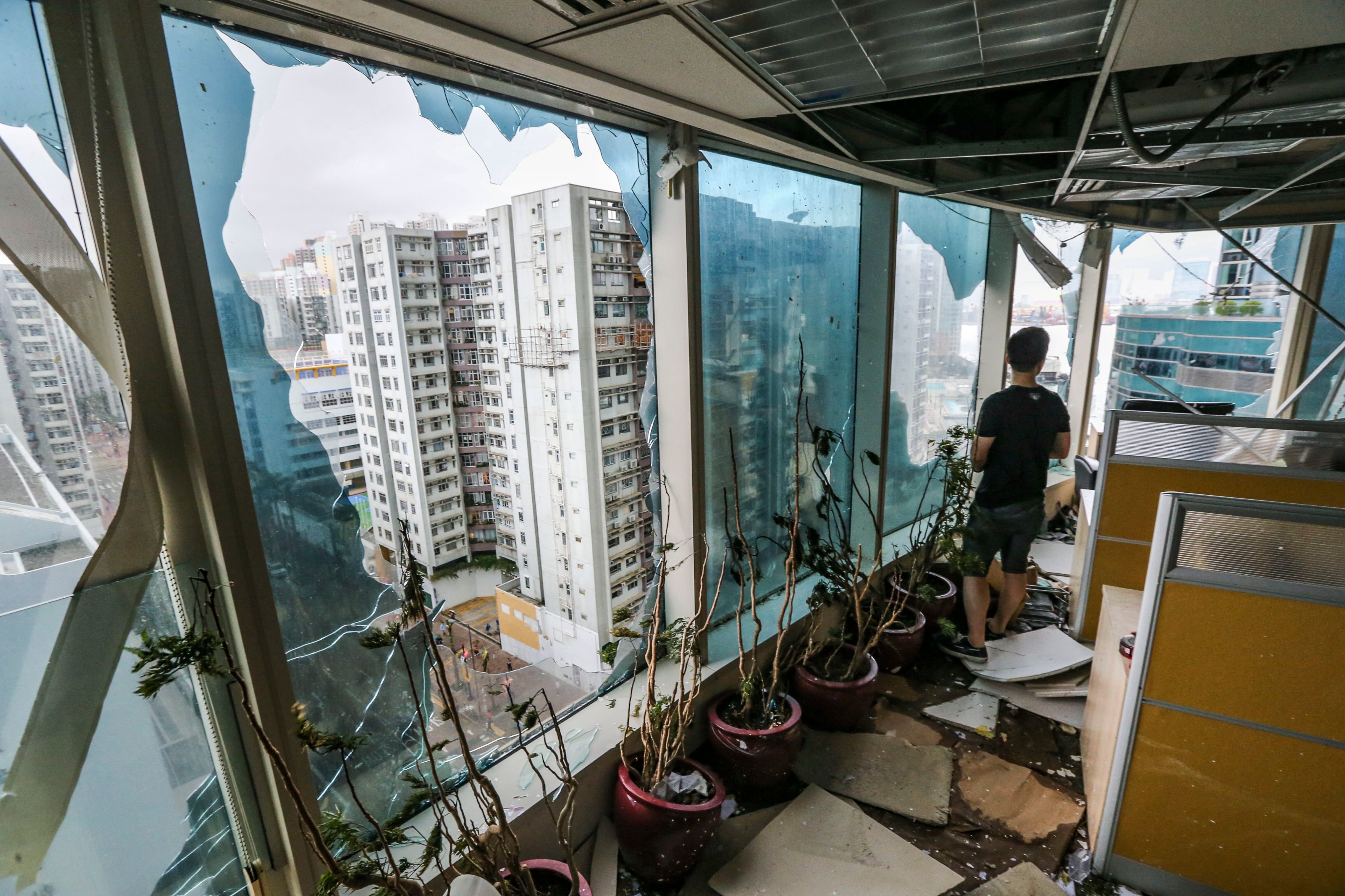 A man inspects damage to the windows of an office in One Harbourfront in Hung Hom after Typhoon Mangkhut hit Hong Kong in 2018. Photo: Felix Wong
