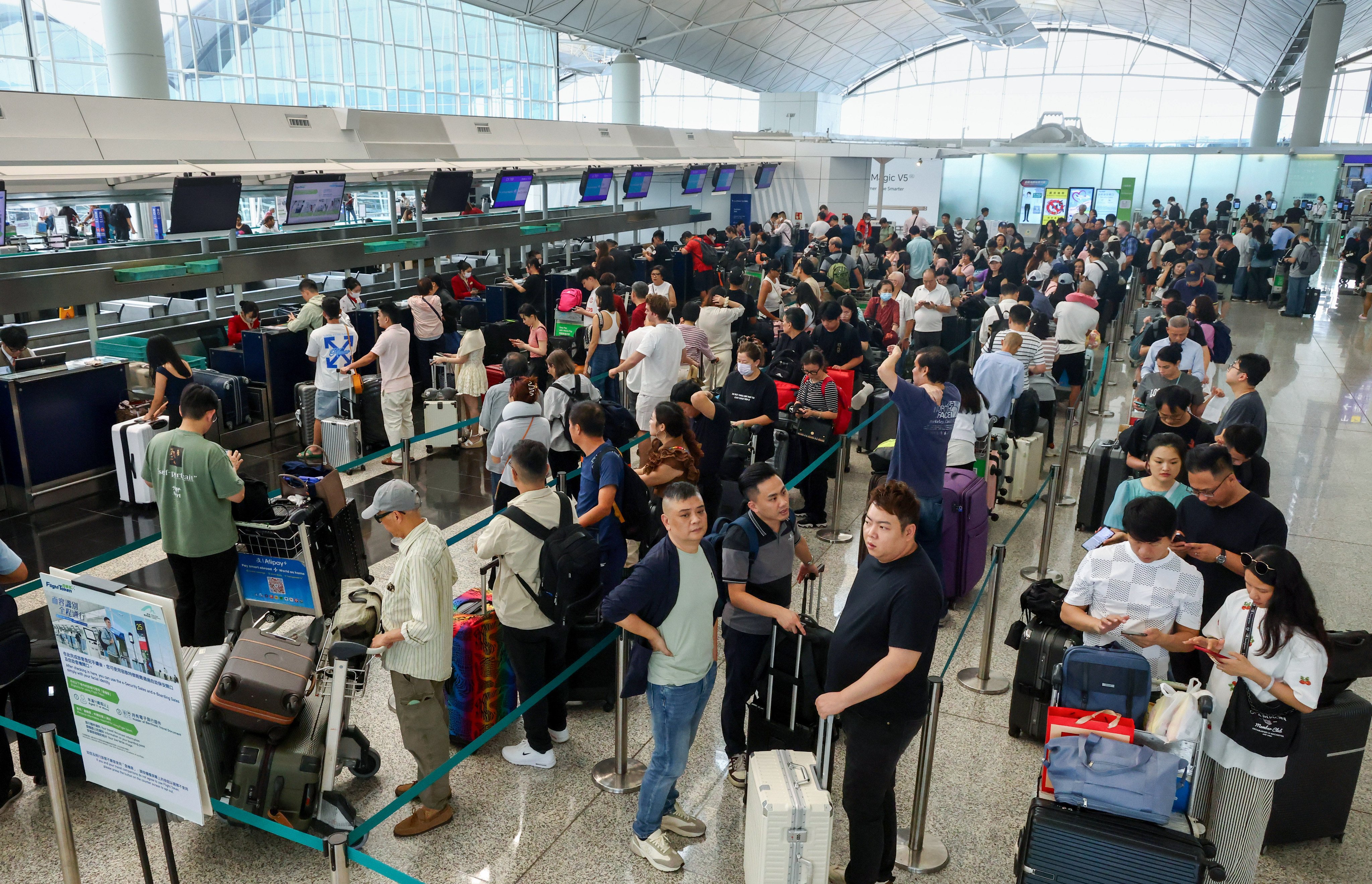 Passengers queue at airline counters at Hong Kong International Airport. Photo: Dickson Lee