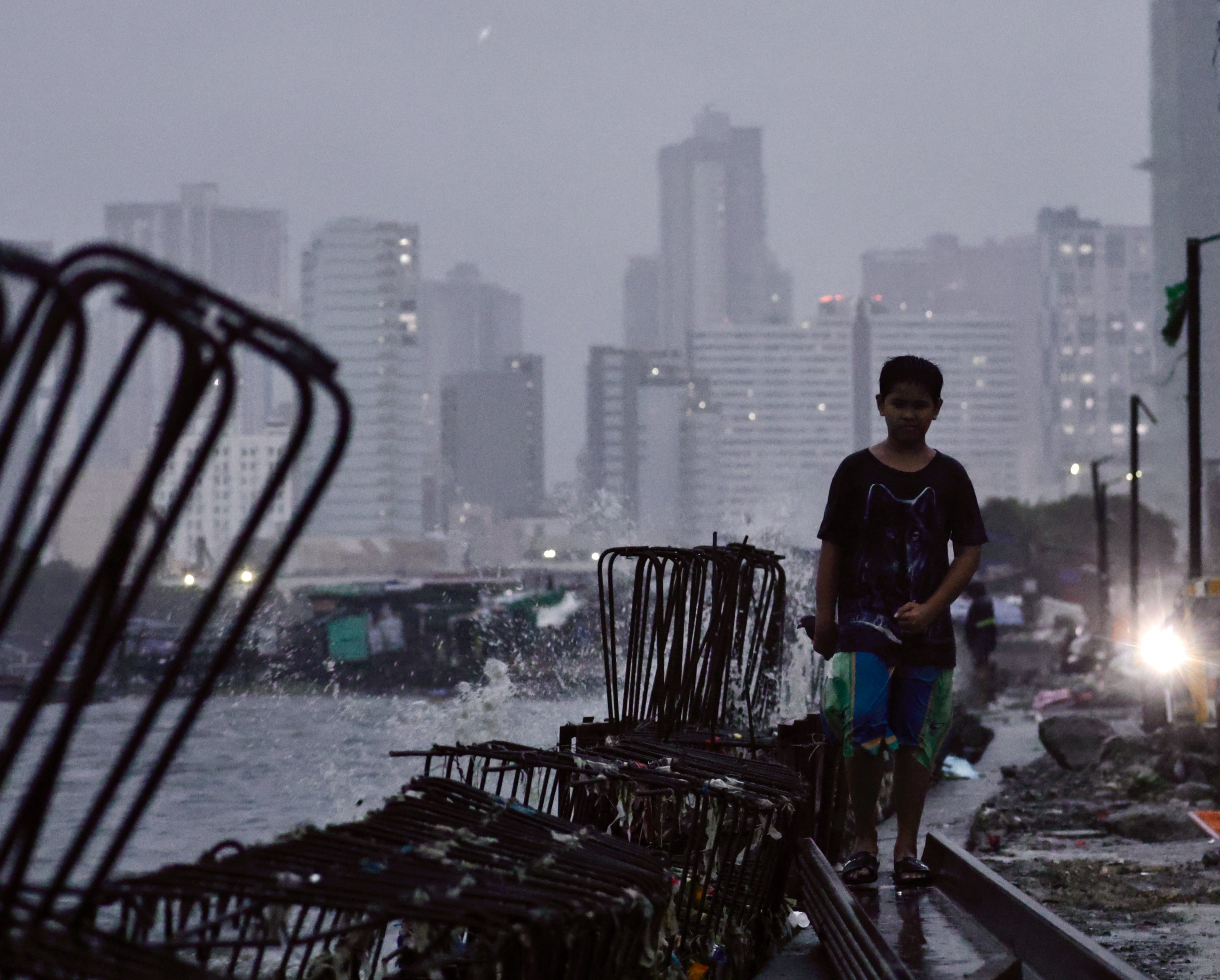 A Filipino boy walks along an unfinished flood control dyke in Manila on Monday. Photo: EPA