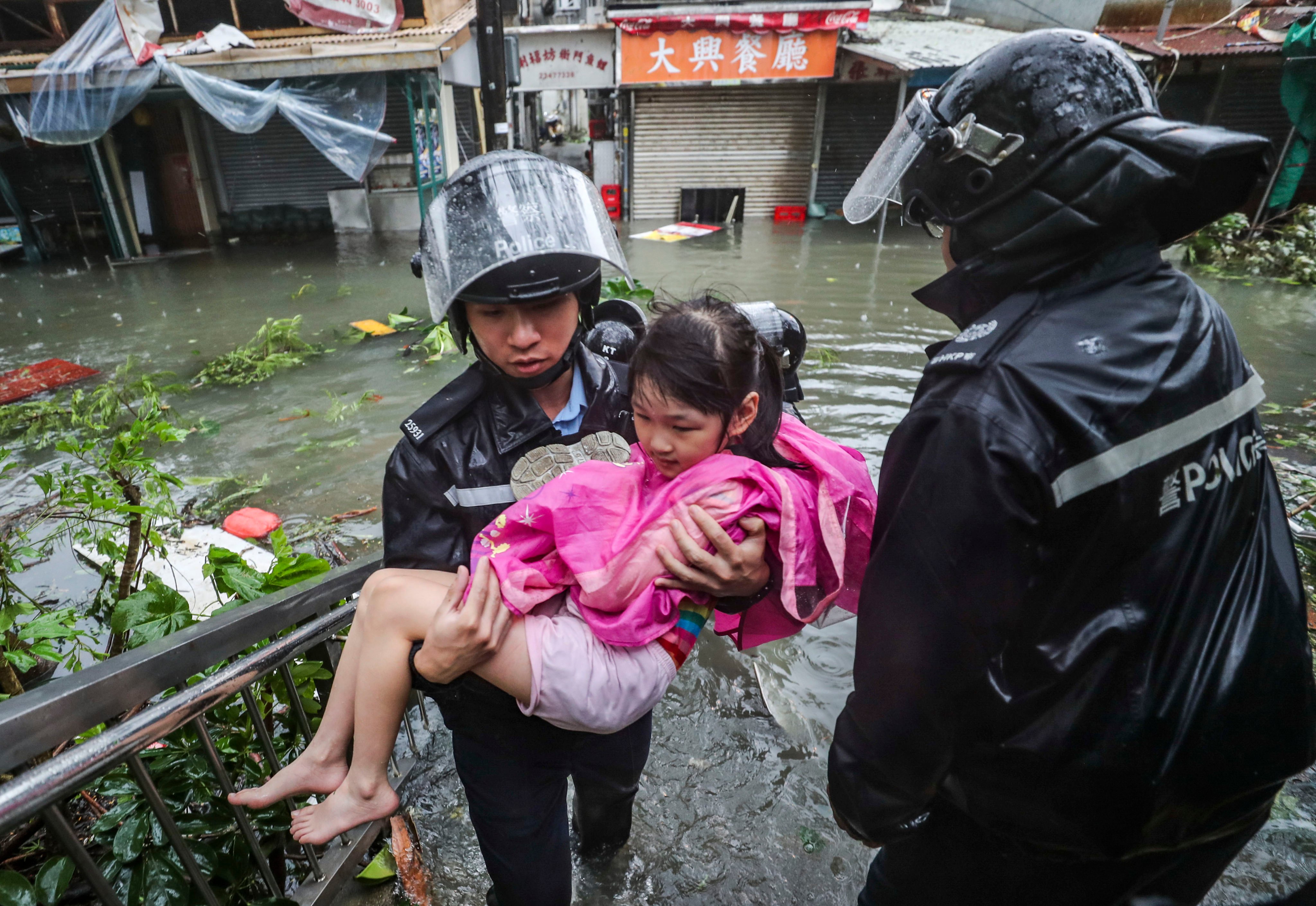 Hong Kong police evacuate a young resident from Lei Yue Mun in the wake of serious flooding caused by Super Typhoon Mangkhut in 2018. Photo: Winson Wong