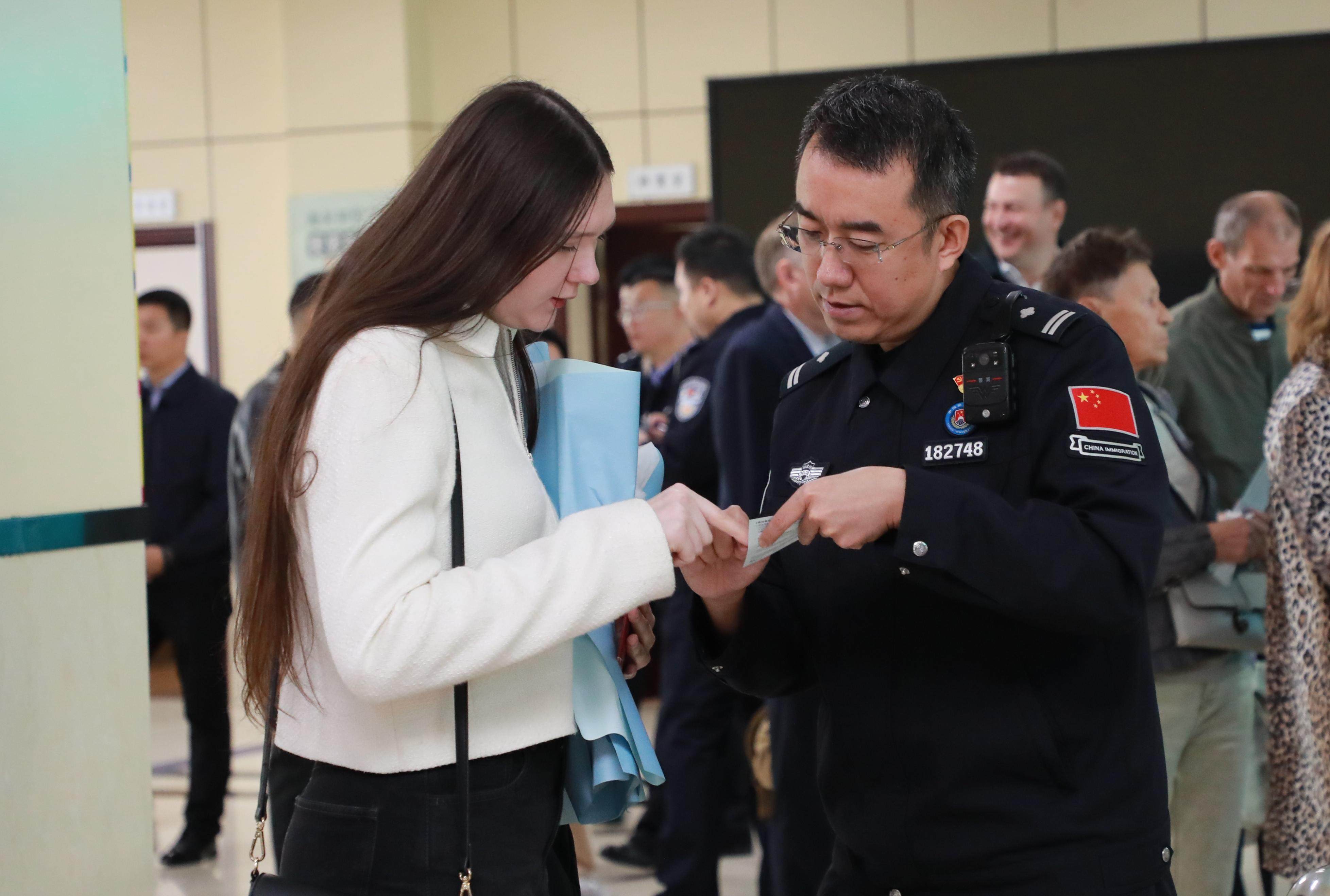 An immigration officer helps a Russian traveler with customs clearance at a port in Heihe, northeast China’s Heilongjiang province, on September 15. Photo: Xinhua