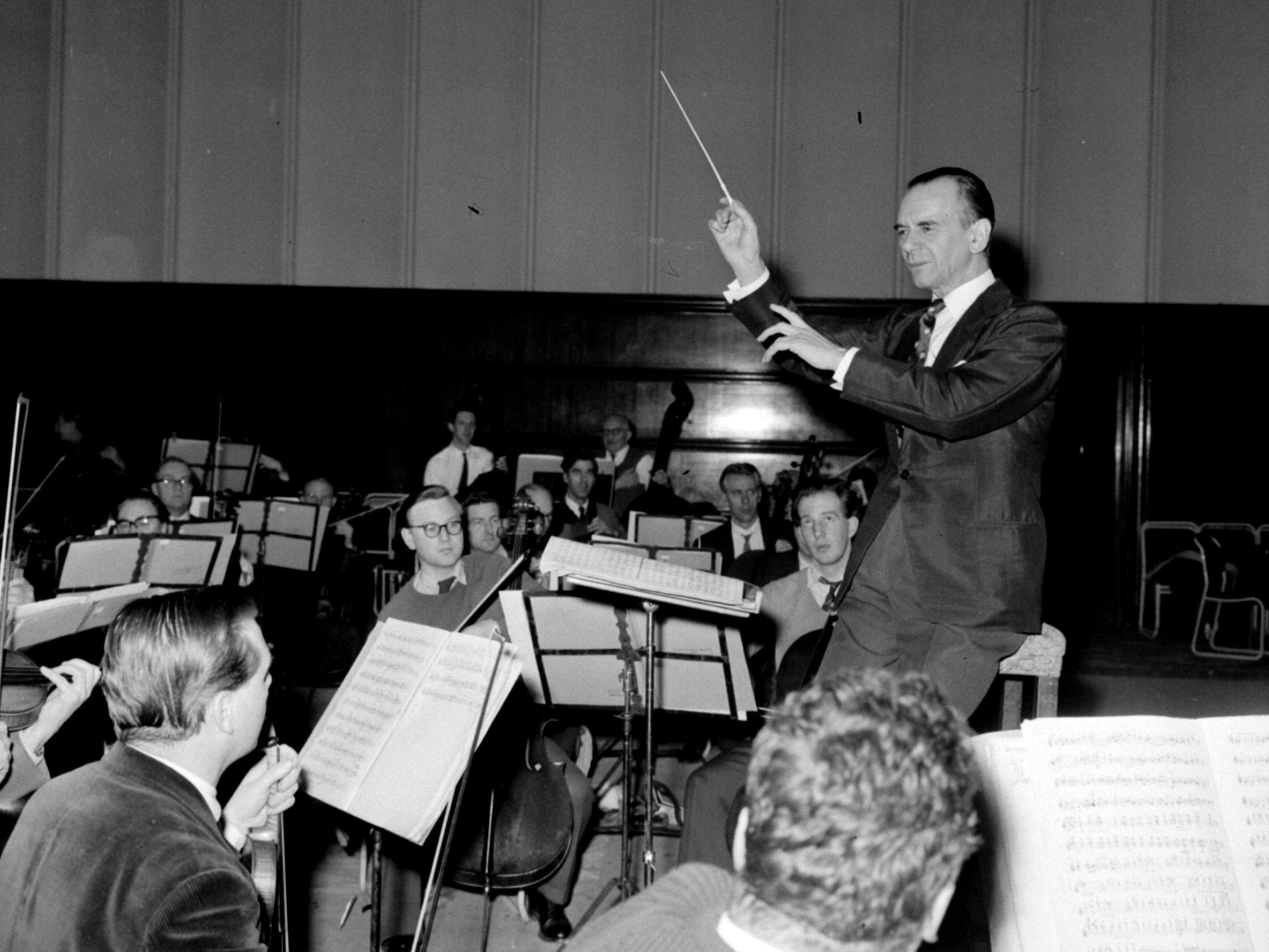 Malcolm Sargent in a final rehearsal with members of the London Philharmonic Orchestra in Hammersmith Town Hall, in preparation for the orchestra’s Asia tour. Photo: PA Images via Getty Images