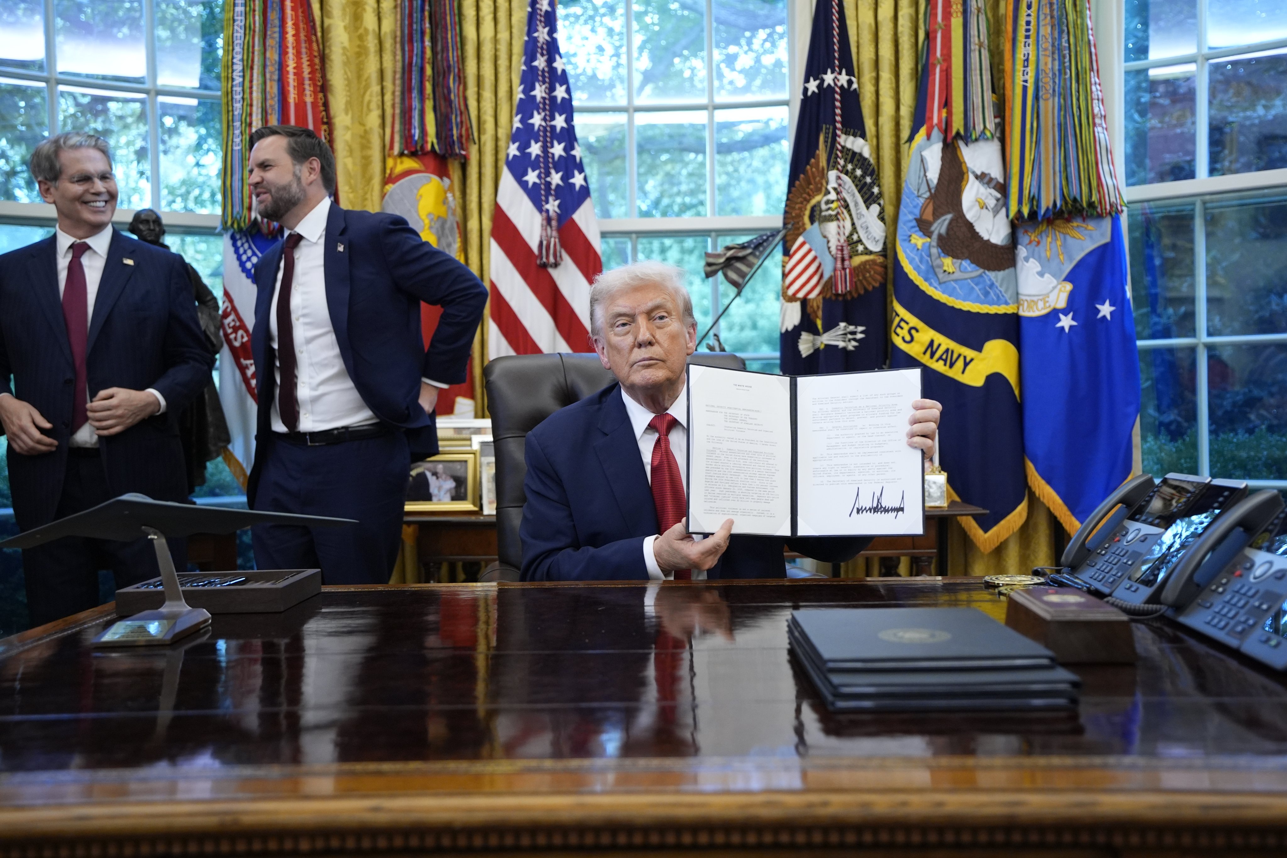 US President Donald Trump (right) signs executive orders in the presence of US Vice-President J.D. Vance (centre) and US Treasury Secretary Scott Bessent in the Oval Office of the White House in Washington on September 25. Photo: EPA