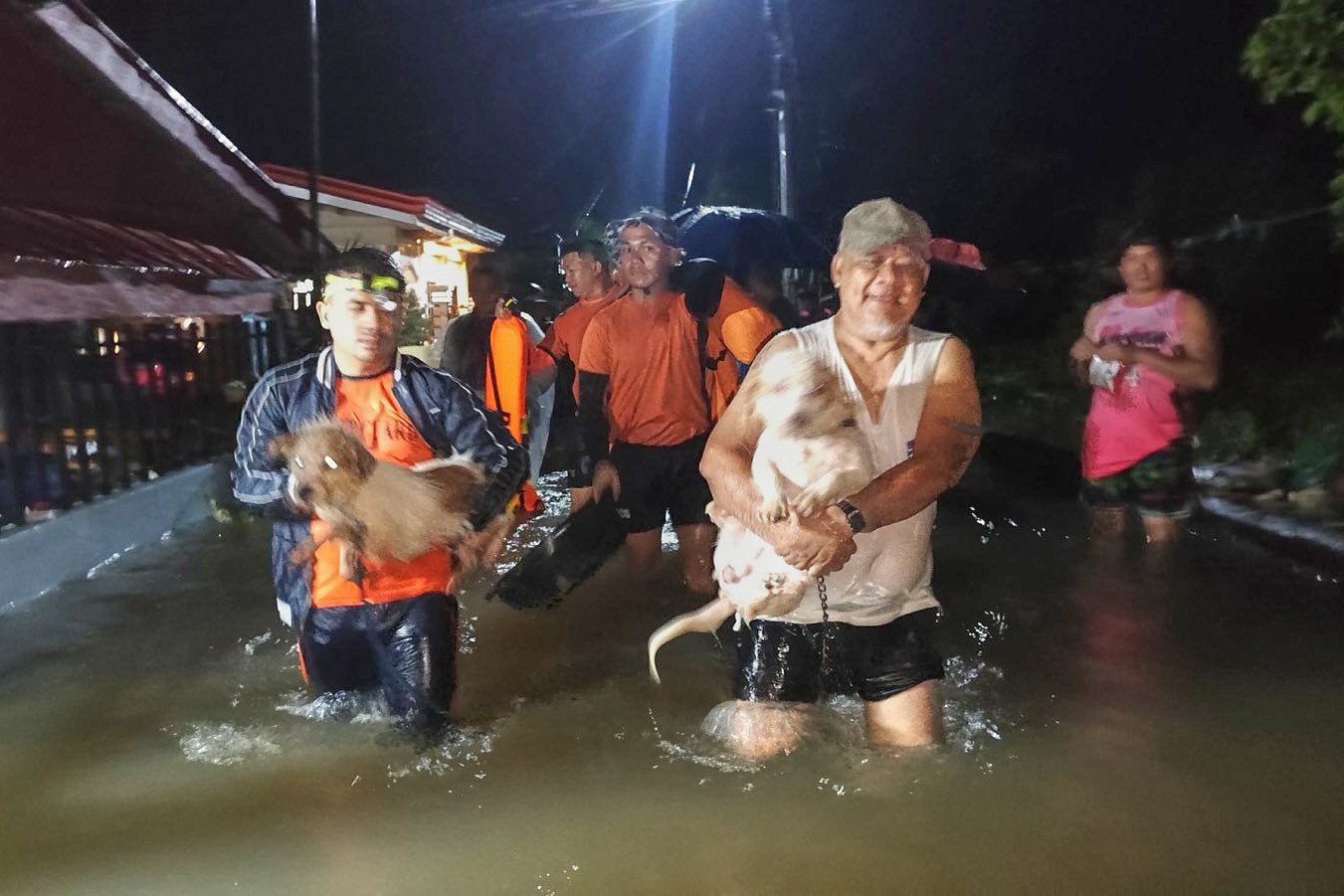 Filipino rescuers help residents and their pets evacuate their flooded homes in Ormoc, Leyte province, Philippines, on Friday. Photo: Philippine Coast Guard/AP