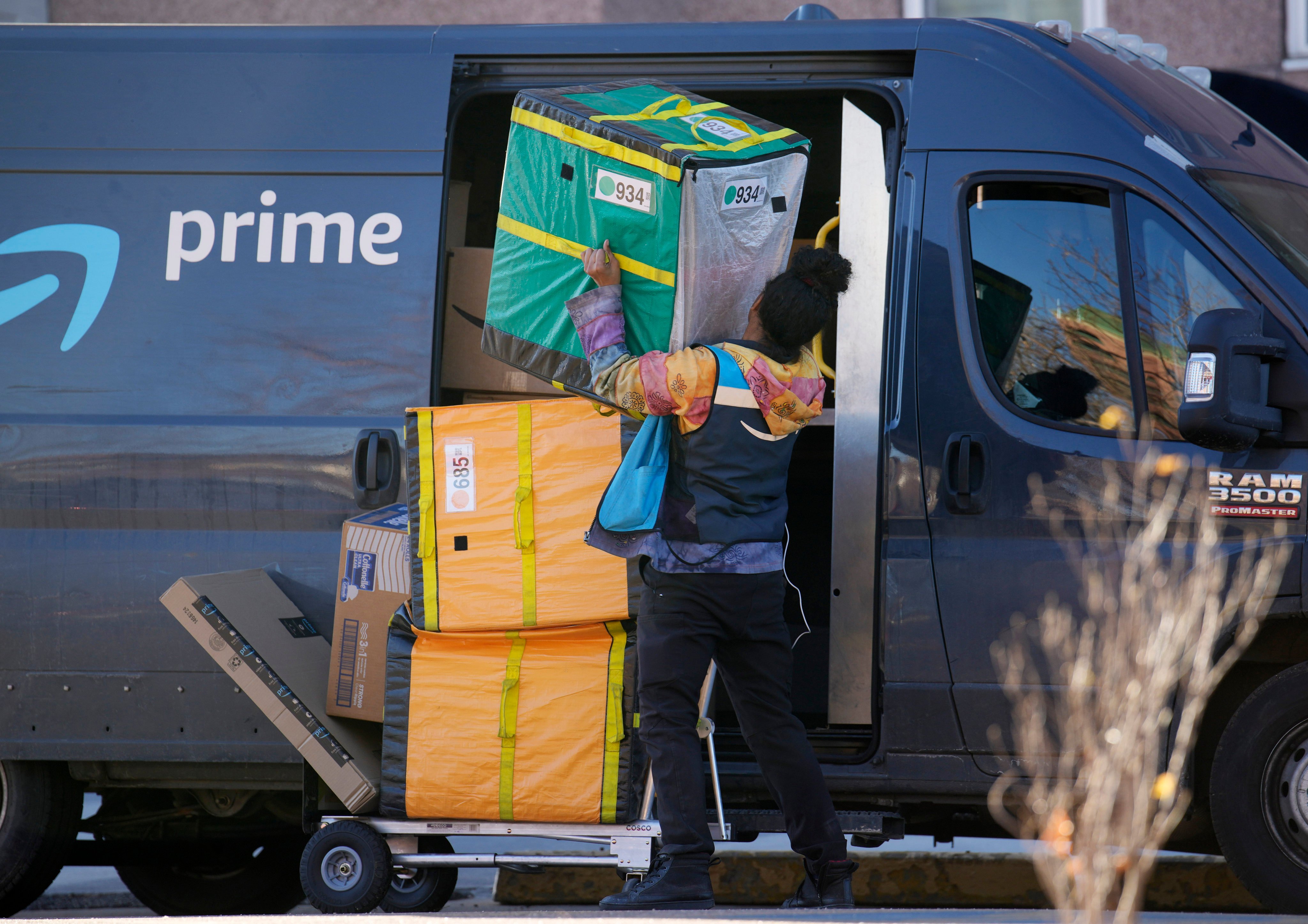 An Amazon Prime delivery person lifts packages while making a stop in Denver in November 2023. Photo: AP