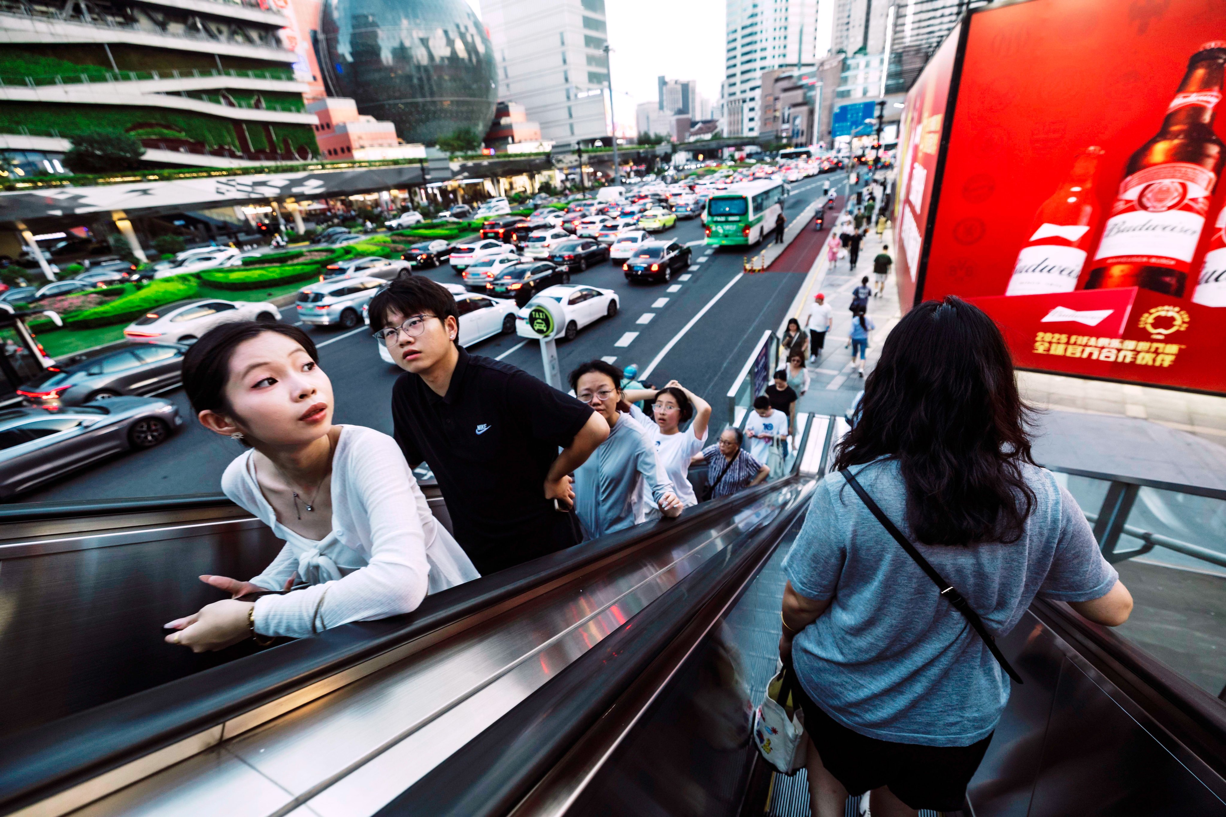 People ride on the escalator in Shanghai, China, 26 August 2025. Photo: EPA